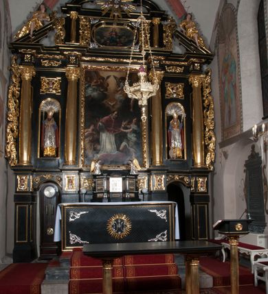 Zdjęcie nr 3: Ołtarz architektoniczny, na wysokim cokole, jednokondygnacyjny, trójosiowy, ze zwieńczeniem; osie wyznaczone umieszczonymi na wysokich cokołach kolumnami o kapitelach kompozytowych, podtrzymującymi występujące nad podporami uproszczone belkowanie i gzyms, ponad nimi trójkątny, przerywany przyczółek. W strefie dolnej, w osiach skrajnych, po bokach mensy bramki zamknięte półkoliście, służące do obejścia ołtarza. Mensa prostopadłościenna, o profilowanym obramieniu antependium i z profilowanymi prostokątnymi płycinami na bokach. Powyżej, w pierwszej kondygnacji, w osiach skrajnych nisze zamknięte łukiem półkolistym z konchami muszlowymi, w osi środkowej prostokątna wnęka na obraz ołtarzowy. Płyciny na cokołach, powyżej półkolistych wnęk oraz na predelli ażurowe, w kształcie prostokąta z uszakami. Zwieńczenie jednoosiowe, flankowane kolumienkami o kapitelach kompozytowych, z występującym nad podporami belkowaniem i gzymsem oraz półkolistym przerywanym przyczółkiem. W polu środkowym owalna profilowana nisza na obraz, ponad którą w szczycie ołtarza gloria promienista. Nastawa flankowana uszakami w z motywów ornamentu małżowinowo-chrząstkowego. Belkowanie, profilowane, prostokątne pole na obraz, predella oraz płyciny na cokołach i powyżej półkolistych wnęk, wypełnione ornamentem małżowinowo-chrząstkowym. Powyżej bramek w części cokołowej podwieszone girlandy. W zwieńczeniu małżowinowo-chrząstkowe uszaki oraz płyciny wypełnione ornamentem małżowinowo-chrząstkowym. W narożach stylizowane liście. Profilowana wnęka na obraz w zwieńczeniu  wypełniona lilijkami. Kolumny, gzymsy i profilowania otworów złocone. Gloria promienista z puttami oraz Okiem Opatrzności na tle trójkąta równobocznego. Antepedium ozdobione romboidalną siatką, w narożach wstęga regencyjna przechodząca w akant. Pośrodku litery IHS w glorii promienistej. W płycinach na cokołach i powyżej wnęk główki puttów. W niszach rzeźby św. Wojciecha i św. Stanisława. W centralnym polu obraz z przedstawieniem św. Grzegorza Wielkiego, w zwieńczeniu Wniebowzięcie Najświętszej Marii Panny. Na przerywanym przyczółku nastawy rzeźby aniołów. Rzeźba anioła po lewej stronie, pełna, całopostaciowa. Anioł ukazany w pozycji półleżącej, w trzech czwartych, z lewą nogą wysuniętą i wzniesioną głową. Ręce ugięte w łokciach i uniesione. Twarz pociągła, włosy ciemne, kręcone, sięgające do ramion i odsłaniające uszy. Anioł odziany jest w długą, złotą suknię, z podwiniętymi rękawami i odsłaniającą lewą nogę. Fałdy głęboko rzeźbione, na kształt litery V i pionowych rurek.Rzeźba anioła po prawej, pełna, całopostaciowa. Anioł ukazany w pozycji półleżącej, w trzech czwartych, z lewą nogą wysuniętą i wzniesioną głową. Lewa ręka ugięta w łokciu i ułożona na piersi, prawa wyprostowana. Twarz pociągła, włosy ciemne, kręcone, sięgające do ramion i odsłaniające uszy. Anioł ubrany w długą, złotą suknię, z podwiniętymi rękawami i odsłaniającą lewą nogę. Fałdy głęboko rzeźbione, na kształt litery V i pionowych rurek.