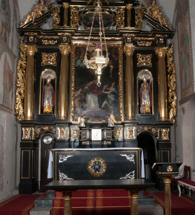 Zdjęcie nr 2: Ołtarz architektoniczny, na wysokim cokole, jednokondygnacyjny, trójosiowy, ze zwieńczeniem; osie wyznaczone umieszczonymi na wysokich cokołach kolumnami o kapitelach kompozytowych, podtrzymującymi występujące nad podporami uproszczone belkowanie i gzyms, ponad nimi trójkątny, przerywany przyczółek. W strefie dolnej, w osiach skrajnych, po bokach mensy bramki zamknięte półkoliście, służące do obejścia ołtarza. Mensa prostopadłościenna, o profilowanym obramieniu antependium i z profilowanymi prostokątnymi płycinami na bokach. Powyżej, w pierwszej kondygnacji, w osiach skrajnych nisze zamknięte łukiem półkolistym z konchami muszlowymi, w osi środkowej prostokątna wnęka na obraz ołtarzowy. Płyciny na cokołach, powyżej półkolistych wnęk oraz na predelli ażurowe, w kształcie prostokąta z uszakami. Zwieńczenie jednoosiowe, flankowane kolumienkami o kapitelach kompozytowych, z występującym nad podporami belkowaniem i gzymsem oraz półkolistym przerywanym przyczółkiem. W polu środkowym owalna profilowana nisza na obraz, ponad którą w szczycie ołtarza gloria promienista. Nastawa flankowana uszakami w z motywów ornamentu małżowinowo-chrząstkowego. Belkowanie, profilowane, prostokątne pole na obraz, predella oraz płyciny na cokołach i powyżej półkolistych wnęk, wypełnione ornamentem małżowinowo-chrząstkowym. Powyżej bramek w części cokołowej podwieszone girlandy. W zwieńczeniu małżowinowo-chrząstkowe uszaki oraz płyciny wypełnione ornamentem małżowinowo-chrząstkowym. W narożach stylizowane liście. Profilowana wnęka na obraz w zwieńczeniu  wypełniona lilijkami. Kolumny, gzymsy i profilowania otworów złocone. Gloria promienista z puttami oraz Okiem Opatrzności na tle trójkąta równobocznego. Antepedium ozdobione romboidalną siatką, w narożach wstęga regencyjna przechodząca w akant. Pośrodku litery IHS w glorii promienistej. W płycinach na cokołach i powyżej wnęk główki puttów. W niszach rzeźby św. Wojciecha i św. Stanisława. W centralnym polu obraz z przedstawieniem św. Grzegorza Wielkiego, w zwieńczeniu Wniebowzięcie Najświętszej Marii Panny. Na przerywanym przyczółku nastawy rzeźby aniołów. Rzeźba anioła po lewej stronie, pełna, całopostaciowa. Anioł ukazany w pozycji półleżącej, w trzech czwartych, z lewą nogą wysuniętą i wzniesioną głową. Ręce ugięte w łokciach i uniesione. Twarz pociągła, włosy ciemne, kręcone, sięgające do ramion i odsłaniające uszy. Anioł odziany jest w długą, złotą suknię, z podwiniętymi rękawami i odsłaniającą lewą nogę. Fałdy głęboko rzeźbione, na kształt litery V i pionowych rurek.Rzeźba anioła po prawej, pełna, całopostaciowa. Anioł ukazany w pozycji półleżącej, w trzech czwartych, z lewą nogą wysuniętą i wzniesioną głową. Lewa ręka ugięta w łokciu i ułożona na piersi, prawa wyprostowana. Twarz pociągła, włosy ciemne, kręcone, sięgające do ramion i odsłaniające uszy. Anioł ubrany w długą, złotą suknię, z podwiniętymi rękawami i odsłaniającą lewą nogę. Fałdy głęboko rzeźbione, na kształt litery V i pionowych rurek.