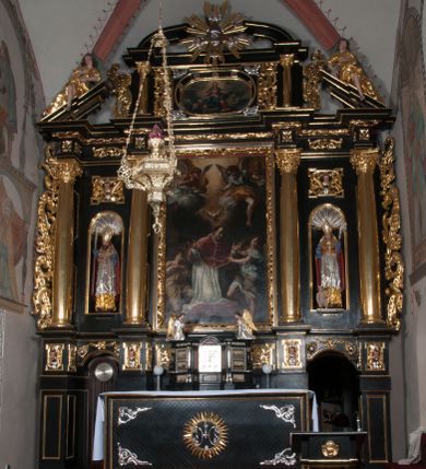 Zdjęcie nr 1: Ołtarz architektoniczny, na wysokim cokole, jednokondygnacyjny, trójosiowy, ze zwieńczeniem; osie wyznaczone umieszczonymi na wysokich cokołach kolumnami o kapitelach kompozytowych, podtrzymującymi występujące nad podporami uproszczone belkowanie i gzyms, ponad nimi trójkątny, przerywany przyczółek. W strefie dolnej, w osiach skrajnych, po bokach mensy bramki zamknięte półkoliście, służące do obejścia ołtarza. Mensa prostopadłościenna, o profilowanym obramieniu antependium i z profilowanymi prostokątnymi płycinami na bokach. Powyżej, w pierwszej kondygnacji, w osiach skrajnych nisze zamknięte łukiem półkolistym z konchami muszlowymi, w osi środkowej prostokątna wnęka na obraz ołtarzowy. Płyciny na cokołach, powyżej półkolistych wnęk oraz na predelli ażurowe, w kształcie prostokąta z uszakami. Zwieńczenie jednoosiowe, flankowane kolumienkami o kapitelach kompozytowych, z występującym nad podporami belkowaniem i gzymsem oraz półkolistym przerywanym przyczółkiem. W polu środkowym owalna profilowana nisza na obraz, ponad którą w szczycie ołtarza gloria promienista. Nastawa flankowana uszakami w z motywów ornamentu małżowinowo-chrząstkowego. Belkowanie, profilowane, prostokątne pole na obraz, predella oraz płyciny na cokołach i powyżej półkolistych wnęk, wypełnione ornamentem małżowinowo-chrząstkowym. Powyżej bramek w części cokołowej podwieszone girlandy. W zwieńczeniu małżowinowo-chrząstkowe uszaki oraz płyciny wypełnione ornamentem małżowinowo-chrząstkowym. W narożach stylizowane liście. Profilowana wnęka na obraz w zwieńczeniu  wypełniona lilijkami. Kolumny, gzymsy i profilowania otworów złocone. Gloria promienista z puttami oraz Okiem Opatrzności na tle trójkąta równobocznego. Antepedium ozdobione romboidalną siatką, w narożach wstęga regencyjna przechodząca w akant. Pośrodku litery IHS w glorii promienistej. W płycinach na cokołach i powyżej wnęk główki puttów. W niszach rzeźby św. Wojciecha i św. Stanisława. W centralnym polu obraz z przedstawieniem św. Grzegorza Wielkiego, w zwieńczeniu Wniebowzięcie Najświętszej Marii Panny. Na przerywanym przyczółku nastawy rzeźby aniołów. Rzeźba anioła po lewej stronie, pełna, całopostaciowa. Anioł ukazany w pozycji półleżącej, w trzech czwartych, z lewą nogą wysuniętą i wzniesioną głową. Ręce ugięte w łokciach i uniesione. Twarz pociągła, włosy ciemne, kręcone, sięgające do ramion i odsłaniające uszy. Anioł odziany jest w długą, złotą suknię, z podwiniętymi rękawami i odsłaniającą lewą nogę. Fałdy głęboko rzeźbione, na kształt litery V i pionowych rurek.Rzeźba anioła po prawej, pełna, całopostaciowa. Anioł ukazany w pozycji półleżącej, w trzech czwartych, z lewą nogą wysuniętą i wzniesioną głową. Lewa ręka ugięta w łokciu i ułożona na piersi, prawa wyprostowana. Twarz pociągła, włosy ciemne, kręcone, sięgające do ramion i odsłaniające uszy. Anioł ubrany w długą, złotą suknię, z podwiniętymi rękawami i odsłaniającą lewą nogę. Fałdy głęboko rzeźbione, na kształt litery V i pionowych rurek.