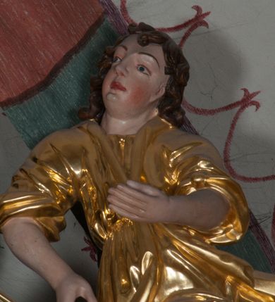 Zdjęcie nr 30: Ołtarz architektoniczny, na wysokim cokole, jednokondygnacyjny, trójosiowy, ze zwieńczeniem; osie wyznaczone umieszczonymi na wysokich cokołach kolumnami o kapitelach kompozytowych, podtrzymującymi występujące nad podporami uproszczone belkowanie i gzyms, ponad nimi trójkątny, przerywany przyczółek. W strefie dolnej, w osiach skrajnych, po bokach mensy bramki zamknięte półkoliście, służące do obejścia ołtarza. Mensa prostopadłościenna, o profilowanym obramieniu antependium i z profilowanymi prostokątnymi płycinami na bokach. Powyżej, w pierwszej kondygnacji, w osiach skrajnych nisze zamknięte łukiem półkolistym z konchami muszlowymi, w osi środkowej prostokątna wnęka na obraz ołtarzowy. Płyciny na cokołach, powyżej półkolistych wnęk oraz na predelli ażurowe, w kształcie prostokąta z uszakami. Zwieńczenie jednoosiowe, flankowane kolumienkami o kapitelach kompozytowych, z występującym nad podporami belkowaniem i gzymsem oraz półkolistym przerywanym przyczółkiem. W polu środkowym owalna profilowana nisza na obraz, ponad którą w szczycie ołtarza gloria promienista. Nastawa flankowana uszakami w z motywów ornamentu małżowinowo-chrząstkowego. Belkowanie, profilowane, prostokątne pole na obraz, predella oraz płyciny na cokołach i powyżej półkolistych wnęk, wypełnione ornamentem małżowinowo-chrząstkowym. Powyżej bramek w części cokołowej podwieszone girlandy. W zwieńczeniu małżowinowo-chrząstkowe uszaki oraz płyciny wypełnione ornamentem małżowinowo-chrząstkowym. W narożach stylizowane liście. Profilowana wnęka na obraz w zwieńczeniu  wypełniona lilijkami. Kolumny, gzymsy i profilowania otworów złocone. Gloria promienista z puttami oraz Okiem Opatrzności na tle trójkąta równobocznego. Antepedium ozdobione romboidalną siatką, w narożach wstęga regencyjna przechodząca w akant. Pośrodku litery IHS w glorii promienistej. W płycinach na cokołach i powyżej wnęk główki puttów. W niszach rzeźby św. Wojciecha i św. Stanisława. W centralnym polu obraz z przedstawieniem św. Grzegorza Wielkiego, w zwieńczeniu Wniebowzięcie Najświętszej Marii Panny. Na przerywanym przyczółku nastawy rzeźby aniołów. Rzeźba anioła po lewej stronie, pełna, całopostaciowa. Anioł ukazany w pozycji półleżącej, w trzech czwartych, z lewą nogą wysuniętą i wzniesioną głową. Ręce ugięte w łokciach i uniesione. Twarz pociągła, włosy ciemne, kręcone, sięgające do ramion i odsłaniające uszy. Anioł odziany jest w długą, złotą suknię, z podwiniętymi rękawami i odsłaniającą lewą nogę. Fałdy głęboko rzeźbione, na kształt litery V i pionowych rurek.Rzeźba anioła po prawej, pełna, całopostaciowa. Anioł ukazany w pozycji półleżącej, w trzech czwartych, z lewą nogą wysuniętą i wzniesioną głową. Lewa ręka ugięta w łokciu i ułożona na piersi, prawa wyprostowana. Twarz pociągła, włosy ciemne, kręcone, sięgające do ramion i odsłaniające uszy. Anioł ubrany w długą, złotą suknię, z podwiniętymi rękawami i odsłaniającą lewą nogę. Fałdy głęboko rzeźbione, na kształt litery V i pionowych rurek.