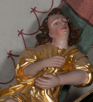 Zdjęcie nr 28: Ołtarz architektoniczny, na wysokim cokole, jednokondygnacyjny, trójosiowy, ze zwieńczeniem; osie wyznaczone umieszczonymi na wysokich cokołach kolumnami o kapitelach kompozytowych, podtrzymującymi występujące nad podporami uproszczone belkowanie i gzyms, ponad nimi trójkątny, przerywany przyczółek. W strefie dolnej, w osiach skrajnych, po bokach mensy bramki zamknięte półkoliście, służące do obejścia ołtarza. Mensa prostopadłościenna, o profilowanym obramieniu antependium i z profilowanymi prostokątnymi płycinami na bokach. Powyżej, w pierwszej kondygnacji, w osiach skrajnych nisze zamknięte łukiem półkolistym z konchami muszlowymi, w osi środkowej prostokątna wnęka na obraz ołtarzowy. Płyciny na cokołach, powyżej półkolistych wnęk oraz na predelli ażurowe, w kształcie prostokąta z uszakami. Zwieńczenie jednoosiowe, flankowane kolumienkami o kapitelach kompozytowych, z występującym nad podporami belkowaniem i gzymsem oraz półkolistym przerywanym przyczółkiem. W polu środkowym owalna profilowana nisza na obraz, ponad którą w szczycie ołtarza gloria promienista. Nastawa flankowana uszakami w z motywów ornamentu małżowinowo-chrząstkowego. Belkowanie, profilowane, prostokątne pole na obraz, predella oraz płyciny na cokołach i powyżej półkolistych wnęk, wypełnione ornamentem małżowinowo-chrząstkowym. Powyżej bramek w części cokołowej podwieszone girlandy. W zwieńczeniu małżowinowo-chrząstkowe uszaki oraz płyciny wypełnione ornamentem małżowinowo-chrząstkowym. W narożach stylizowane liście. Profilowana wnęka na obraz w zwieńczeniu  wypełniona lilijkami. Kolumny, gzymsy i profilowania otworów złocone. Gloria promienista z puttami oraz Okiem Opatrzności na tle trójkąta równobocznego. Antepedium ozdobione romboidalną siatką, w narożach wstęga regencyjna przechodząca w akant. Pośrodku litery IHS w glorii promienistej. W płycinach na cokołach i powyżej wnęk główki puttów. W niszach rzeźby św. Wojciecha i św. Stanisława. W centralnym polu obraz z przedstawieniem św. Grzegorza Wielkiego, w zwieńczeniu Wniebowzięcie Najświętszej Marii Panny. Na przerywanym przyczółku nastawy rzeźby aniołów. Rzeźba anioła po lewej stronie, pełna, całopostaciowa. Anioł ukazany w pozycji półleżącej, w trzech czwartych, z lewą nogą wysuniętą i wzniesioną głową. Ręce ugięte w łokciach i uniesione. Twarz pociągła, włosy ciemne, kręcone, sięgające do ramion i odsłaniające uszy. Anioł odziany jest w długą, złotą suknię, z podwiniętymi rękawami i odsłaniającą lewą nogę. Fałdy głęboko rzeźbione, na kształt litery V i pionowych rurek.Rzeźba anioła po prawej, pełna, całopostaciowa. Anioł ukazany w pozycji półleżącej, w trzech czwartych, z lewą nogą wysuniętą i wzniesioną głową. Lewa ręka ugięta w łokciu i ułożona na piersi, prawa wyprostowana. Twarz pociągła, włosy ciemne, kręcone, sięgające do ramion i odsłaniające uszy. Anioł ubrany w długą, złotą suknię, z podwiniętymi rękawami i odsłaniającą lewą nogę. Fałdy głęboko rzeźbione, na kształt litery V i pionowych rurek.