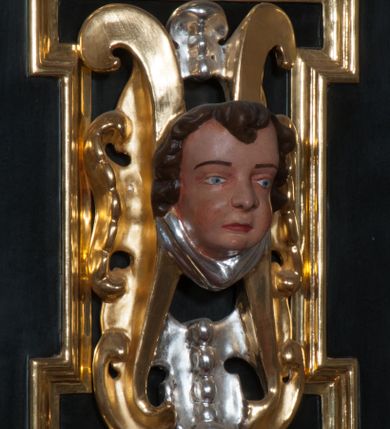 Zdjęcie nr 34: Ołtarz architektoniczny, na wysokim cokole, jednokondygnacyjny, trójosiowy, ze zwieńczeniem; osie wyznaczone umieszczonymi na wysokich cokołach kolumnami o kapitelach kompozytowych, podtrzymującymi występujące nad podporami uproszczone belkowanie i gzyms, ponad nimi trójkątny, przerywany przyczółek. W strefie dolnej, w osiach skrajnych, po bokach mensy bramki zamknięte półkoliście, służące do obejścia ołtarza. Mensa prostopadłościenna, o profilowanym obramieniu antependium i z profilowanymi prostokątnymi płycinami na bokach. Powyżej, w pierwszej kondygnacji, w osiach skrajnych nisze zamknięte łukiem półkolistym z konchami muszlowymi, w osi środkowej prostokątna wnęka na obraz ołtarzowy. Płyciny na cokołach, powyżej półkolistych wnęk oraz na predelli ażurowe, w kształcie prostokąta z uszakami. Zwieńczenie jednoosiowe, flankowane kolumienkami o kapitelach kompozytowych, z występującym nad podporami belkowaniem i gzymsem oraz półkolistym przerywanym przyczółkiem. W polu środkowym owalna profilowana nisza na obraz, ponad którą w szczycie ołtarza gloria promienista. Nastawa flankowana uszakami w z motywów ornamentu małżowinowo-chrząstkowego. Belkowanie, profilowane, prostokątne pole na obraz, predella oraz płyciny na cokołach i powyżej półkolistych wnęk, wypełnione ornamentem małżowinowo-chrząstkowym. Powyżej bramek w części cokołowej podwieszone girlandy. W zwieńczeniu małżowinowo-chrząstkowe uszaki oraz płyciny wypełnione ornamentem małżowinowo-chrząstkowym. W narożach stylizowane liście. Profilowana wnęka na obraz w zwieńczeniu  wypełniona lilijkami. Kolumny, gzymsy i profilowania otworów złocone. Gloria promienista z puttami oraz Okiem Opatrzności na tle trójkąta równobocznego. Antepedium ozdobione romboidalną siatką, w narożach wstęga regencyjna przechodząca w akant. Pośrodku litery IHS w glorii promienistej. W płycinach na cokołach i powyżej wnęk główki puttów. W niszach rzeźby św. Wojciecha i św. Stanisława. W centralnym polu obraz z przedstawieniem św. Grzegorza Wielkiego, w zwieńczeniu Wniebowzięcie Najświętszej Marii Panny. Na przerywanym przyczółku nastawy rzeźby aniołów. Rzeźba anioła po lewej stronie, pełna, całopostaciowa. Anioł ukazany w pozycji półleżącej, w trzech czwartych, z lewą nogą wysuniętą i wzniesioną głową. Ręce ugięte w łokciach i uniesione. Twarz pociągła, włosy ciemne, kręcone, sięgające do ramion i odsłaniające uszy. Anioł odziany jest w długą, złotą suknię, z podwiniętymi rękawami i odsłaniającą lewą nogę. Fałdy głęboko rzeźbione, na kształt litery V i pionowych rurek.Rzeźba anioła po prawej, pełna, całopostaciowa. Anioł ukazany w pozycji półleżącej, w trzech czwartych, z lewą nogą wysuniętą i wzniesioną głową. Lewa ręka ugięta w łokciu i ułożona na piersi, prawa wyprostowana. Twarz pociągła, włosy ciemne, kręcone, sięgające do ramion i odsłaniające uszy. Anioł ubrany w długą, złotą suknię, z podwiniętymi rękawami i odsłaniającą lewą nogę. Fałdy głęboko rzeźbione, na kształt litery V i pionowych rurek.