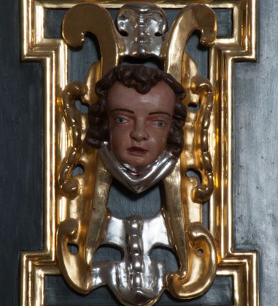 Zdjęcie nr 31: Ołtarz architektoniczny, na wysokim cokole, jednokondygnacyjny, trójosiowy, ze zwieńczeniem; osie wyznaczone umieszczonymi na wysokich cokołach kolumnami o kapitelach kompozytowych, podtrzymującymi występujące nad podporami uproszczone belkowanie i gzyms, ponad nimi trójkątny, przerywany przyczółek. W strefie dolnej, w osiach skrajnych, po bokach mensy bramki zamknięte półkoliście, służące do obejścia ołtarza. Mensa prostopadłościenna, o profilowanym obramieniu antependium i z profilowanymi prostokątnymi płycinami na bokach. Powyżej, w pierwszej kondygnacji, w osiach skrajnych nisze zamknięte łukiem półkolistym z konchami muszlowymi, w osi środkowej prostokątna wnęka na obraz ołtarzowy. Płyciny na cokołach, powyżej półkolistych wnęk oraz na predelli ażurowe, w kształcie prostokąta z uszakami. Zwieńczenie jednoosiowe, flankowane kolumienkami o kapitelach kompozytowych, z występującym nad podporami belkowaniem i gzymsem oraz półkolistym przerywanym przyczółkiem. W polu środkowym owalna profilowana nisza na obraz, ponad którą w szczycie ołtarza gloria promienista. Nastawa flankowana uszakami w z motywów ornamentu małżowinowo-chrząstkowego. Belkowanie, profilowane, prostokątne pole na obraz, predella oraz płyciny na cokołach i powyżej półkolistych wnęk, wypełnione ornamentem małżowinowo-chrząstkowym. Powyżej bramek w części cokołowej podwieszone girlandy. W zwieńczeniu małżowinowo-chrząstkowe uszaki oraz płyciny wypełnione ornamentem małżowinowo-chrząstkowym. W narożach stylizowane liście. Profilowana wnęka na obraz w zwieńczeniu  wypełniona lilijkami. Kolumny, gzymsy i profilowania otworów złocone. Gloria promienista z puttami oraz Okiem Opatrzności na tle trójkąta równobocznego. Antepedium ozdobione romboidalną siatką, w narożach wstęga regencyjna przechodząca w akant. Pośrodku litery IHS w glorii promienistej. W płycinach na cokołach i powyżej wnęk główki puttów. W niszach rzeźby św. Wojciecha i św. Stanisława. W centralnym polu obraz z przedstawieniem św. Grzegorza Wielkiego, w zwieńczeniu Wniebowzięcie Najświętszej Marii Panny. Na przerywanym przyczółku nastawy rzeźby aniołów. Rzeźba anioła po lewej stronie, pełna, całopostaciowa. Anioł ukazany w pozycji półleżącej, w trzech czwartych, z lewą nogą wysuniętą i wzniesioną głową. Ręce ugięte w łokciach i uniesione. Twarz pociągła, włosy ciemne, kręcone, sięgające do ramion i odsłaniające uszy. Anioł odziany jest w długą, złotą suknię, z podwiniętymi rękawami i odsłaniającą lewą nogę. Fałdy głęboko rzeźbione, na kształt litery V i pionowych rurek.Rzeźba anioła po prawej, pełna, całopostaciowa. Anioł ukazany w pozycji półleżącej, w trzech czwartych, z lewą nogą wysuniętą i wzniesioną głową. Lewa ręka ugięta w łokciu i ułożona na piersi, prawa wyprostowana. Twarz pociągła, włosy ciemne, kręcone, sięgające do ramion i odsłaniające uszy. Anioł ubrany w długą, złotą suknię, z podwiniętymi rękawami i odsłaniającą lewą nogę. Fałdy głęboko rzeźbione, na kształt litery V i pionowych rurek.