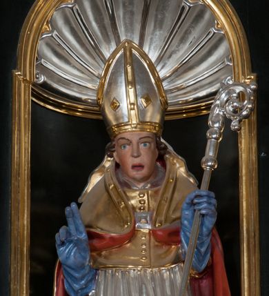 Zdjęcie nr 19: Ołtarz architektoniczny, na wysokim cokole, jednokondygnacyjny, trójosiowy, ze zwieńczeniem; osie wyznaczone umieszczonymi na wysokich cokołach kolumnami o kapitelach kompozytowych, podtrzymującymi występujące nad podporami uproszczone belkowanie i gzyms, ponad nimi trójkątny, przerywany przyczółek. W strefie dolnej, w osiach skrajnych, po bokach mensy bramki zamknięte półkoliście, służące do obejścia ołtarza. Mensa prostopadłościenna, o profilowanym obramieniu antependium i z profilowanymi prostokątnymi płycinami na bokach. Powyżej, w pierwszej kondygnacji, w osiach skrajnych nisze zamknięte łukiem półkolistym z konchami muszlowymi, w osi środkowej prostokątna wnęka na obraz ołtarzowy. Płyciny na cokołach, powyżej półkolistych wnęk oraz na predelli ażurowe, w kształcie prostokąta z uszakami. Zwieńczenie jednoosiowe, flankowane kolumienkami o kapitelach kompozytowych, z występującym nad podporami belkowaniem i gzymsem oraz półkolistym przerywanym przyczółkiem. W polu środkowym owalna profilowana nisza na obraz, ponad którą w szczycie ołtarza gloria promienista. Nastawa flankowana uszakami w z motywów ornamentu małżowinowo-chrząstkowego. Belkowanie, profilowane, prostokątne pole na obraz, predella oraz płyciny na cokołach i powyżej półkolistych wnęk, wypełnione ornamentem małżowinowo-chrząstkowym. Powyżej bramek w części cokołowej podwieszone girlandy. W zwieńczeniu małżowinowo-chrząstkowe uszaki oraz płyciny wypełnione ornamentem małżowinowo-chrząstkowym. W narożach stylizowane liście. Profilowana wnęka na obraz w zwieńczeniu  wypełniona lilijkami. Kolumny, gzymsy i profilowania otworów złocone. Gloria promienista z puttami oraz Okiem Opatrzności na tle trójkąta równobocznego. Antepedium ozdobione romboidalną siatką, w narożach wstęga regencyjna przechodząca w akant. Pośrodku litery IHS w glorii promienistej. W płycinach na cokołach i powyżej wnęk główki puttów. W niszach rzeźby św. Wojciecha i św. Stanisława. W centralnym polu obraz z przedstawieniem św. Grzegorza Wielkiego, w zwieńczeniu Wniebowzięcie Najświętszej Marii Panny. Na przerywanym przyczółku nastawy rzeźby aniołów. Rzeźba anioła po lewej stronie, pełna, całopostaciowa. Anioł ukazany w pozycji półleżącej, w trzech czwartych, z lewą nogą wysuniętą i wzniesioną głową. Ręce ugięte w łokciach i uniesione. Twarz pociągła, włosy ciemne, kręcone, sięgające do ramion i odsłaniające uszy. Anioł odziany jest w długą, złotą suknię, z podwiniętymi rękawami i odsłaniającą lewą nogę. Fałdy głęboko rzeźbione, na kształt litery V i pionowych rurek.Rzeźba anioła po prawej, pełna, całopostaciowa. Anioł ukazany w pozycji półleżącej, w trzech czwartych, z lewą nogą wysuniętą i wzniesioną głową. Lewa ręka ugięta w łokciu i ułożona na piersi, prawa wyprostowana. Twarz pociągła, włosy ciemne, kręcone, sięgające do ramion i odsłaniające uszy. Anioł ubrany w długą, złotą suknię, z podwiniętymi rękawami i odsłaniającą lewą nogę. Fałdy głęboko rzeźbione, na kształt litery V i pionowych rurek.