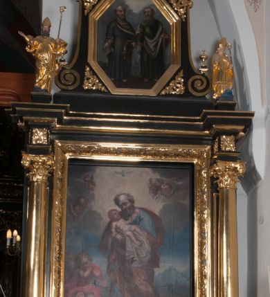 Zdjęcie nr 2: Nastawa ołtarzowa architektoniczna, jednoosiowa, jednokondygnacyjna, ze zwieńczeniem, flankowana kolumnami o kompozytowych kapitelach. Kolumny, umieszczone na prostokątnych postumentach, wspierają występujące nad podporami uproszczone belkowanie i gzyms. Pośrodku prostokątna nisza na obraz. Zwieńczenie flankowane spływami wolutowymi, z wazonami, zamknięte falistym, wklęsło-wypukłym gzymsem. Pośrodku ośmioboczna profilowana nisza na obraz. Po bokach zwieńczenia, w osiach kolumn, na postumentach rzeźby św. Wojciecha i św. Stanisława. Ołtarz zwieńczony rzeźbą św. Jakuba Starszego.Na fryzie i narożach zwieńczenia ornamenty roślinne. Mensa prostopadłościenna; antenpedium w profilowanej ramie, ozdobione ukośną kratką, z Gorejącym Sercem oplecionym cierniem pośrodku oraz rozetą wśród stylizowanych liści w narożach. Na ściankach bocznych po jednej prostokątnej płycinie. W polu środkowym nastawy obraz z przedstawieniem św. Józefa, w polu zwieńczenia obraz z przedstawieniem śś. Piotra i Pawła. Struktura ołtarza malowana na czarno; kolumny, detale architektoniczne i motywy ornamentalne złocone.
