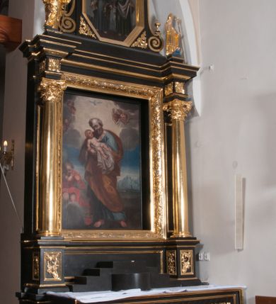 Zdjęcie nr 4: Nastawa ołtarzowa architektoniczna, jednoosiowa, jednokondygnacyjna, ze zwieńczeniem, flankowana kolumnami o kompozytowych kapitelach. Kolumny, umieszczone na prostokątnych postumentach, wspierają występujące nad podporami uproszczone belkowanie i gzyms. Pośrodku prostokątna nisza na obraz. Zwieńczenie flankowane spływami wolutowymi, z wazonami, zamknięte falistym, wklęsło-wypukłym gzymsem. Pośrodku ośmioboczna profilowana nisza na obraz. Po bokach zwieńczenia, w osiach kolumn, na postumentach rzeźby św. Wojciecha i św. Stanisława. Ołtarz zwieńczony rzeźbą św. Jakuba Starszego.Na fryzie i narożach zwieńczenia ornamenty roślinne. Mensa prostopadłościenna; antenpedium w profilowanej ramie, ozdobione ukośną kratką, z Gorejącym Sercem oplecionym cierniem pośrodku oraz rozetą wśród stylizowanych liści w narożach. Na ściankach bocznych po jednej prostokątnej płycinie. W polu środkowym nastawy obraz z przedstawieniem św. Józefa, w polu zwieńczenia obraz z przedstawieniem śś. Piotra i Pawła. Struktura ołtarza malowana na czarno; kolumny, detale architektoniczne i motywy ornamentalne złocone.
