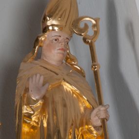 Zdjęcie nr 1: Rzeźba polichromowana i złocona. Święty ukazany frontalnie, w pozycji stojącej, z prawą ręką ugiętą w łokciu i z otwartą dłonią uniesioną na wysokości piersi, skierowaną do widza w wymownym geście. W lewej trzyma pastorał. U jego stóp, z prawej strony przedstawiono z profilu, w pozycji klęczącej Piotrowina, ze złożonymi rękoma, z twarzą uniesioną ku górze, skierowaną w stronę Świętego. Stanisław ubrany w strój liturgiczny: albę, rokietę i kapę spiętą na piersiach. Szaty złote, pofałdowane. Suknia Piotrowina w kolorze niebieskim. Karnacje w kolorze naturalnym.