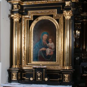 Zdjęcie nr 1: Nastawa ołtarzowa architektoniczna, jednokondygnacyjna, jednoosiowa, ze zwieńczeniem. Pole środkowe flankowane kolumnami o kompozytowych kapitelach, umieszczonymi na wysokich, prostopadłościennych postumentach i dźwigającymi uproszczone belkowanie i wydatny profilowany gzyms, występujące nad podporami. Pomiędzy kolumnami prostokątna zamknięta schodkowo nisza na obraz ołtarzowy, ujęta złoconą ramą zdobioną motywami roślinnymi. W niszy obraz Matki Boskiej z Dzieciątkiem, w kształcie prostokąta zamkniętego łukiem półpełnym, ujęty w osobną gładką złoconą ramę. Postumenty pod kolumny i belkowanie ozdobiony ażurowymi złoconymi płycinami z dekoracją ornamentalną. Zwieńczenie w kształcie prostokąta zakończone profilowanym, falistym gzymsem wspartym na dwóch złoconych, kanelowanych pilastrach, ujęte po bokach spływami wolutowymi. W polu zwieńczenia ośmioboczny obraz z przedstawieniem św. Dominika odbierającego różaniec z rąk Matki Boskiej z Dzieciątkiem, w bogatej złoconej ramie. Wokół ramy obrazu ażurowe motywy ornamentalne i rozetki. Na gzymsach w osiach kolumn oraz w osi zwieńczenia rzeźby uskrzydlonych aniołów. Mensa prostopadłościenna; antependium w profilowanym obramieniu, ozdobione ukośną kratką, pośrodku splecione litery imienia Maria, w narożach motywy liści. Boki mensy ozdobione prostokątnymi płycinami. Struktura ołtarza malowana na czarno, kolumny, motywy ornamentalne i gzymsy złocone.