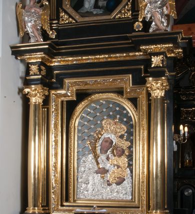 Zdjęcie nr 9: Nastawa ołtarzowa architektoniczna, jednokondygnacyjna, jednoosiowa, ze zwieńczeniem. Pole środkowe flankowane kolumnami o kompozytowych kapitelach, umieszczonymi na wysokich, prostopadłościennych postumentach i dźwigającymi uproszczone belkowanie i wydatny profilowany gzyms, występujące nad podporami. Pomiędzy kolumnami prostokątna zamknięta schodkowo nisza na obraz ołtarzowy, ujęta złoconą ramą zdobioną motywami roślinnymi. W niszy obraz Matki Boskiej z Dzieciątkiem, w kształcie prostokąta zamkniętego łukiem półpełnym, ujęty w osobną gładką złoconą ramę. Postumenty pod kolumny i belkowanie ozdobiony ażurowymi złoconymi płycinami z dekoracją ornamentalną. Zwieńczenie w kształcie prostokąta zakończone profilowanym, falistym gzymsem wspartym na dwóch złoconych, kanelowanych pilastrach, ujęte po bokach spływami wolutowymi. W polu zwieńczenia ośmioboczny obraz z przedstawieniem św. Dominika odbierającego różaniec z rąk Matki Boskiej z Dzieciątkiem, w bogatej złoconej ramie. Wokół ramy obrazu ażurowe motywy ornamentalne i rozetki. Na gzymsach w osiach kolumn oraz w osi zwieńczenia rzeźby uskrzydlonych aniołów. Mensa prostopadłościenna; antependium w profilowanym obramieniu, ozdobione ukośną kratką, pośrodku splecione litery imienia Maria, w narożach motywy liści. Boki mensy ozdobione prostokątnymi płycinami. Struktura ołtarza malowana na czarno, kolumny, motywy ornamentalne i gzymsy złocone.