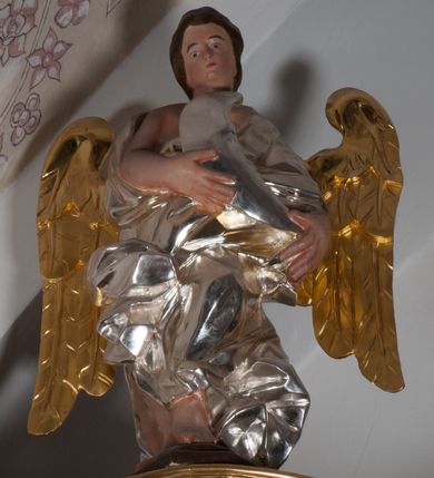 Zdjęcie nr 3: Anioł nad lewą kolumną ujęty w kontrapoście, z lewą ręką przyłożoną do torsu. Głowa odchylona na lewe ramię. Skrzydła złocone, umieszczone symetrycznie. Malowane w kolorze naturalnym, nagie ciało okryte srebrną, fałdowaną draperią. Prawe ramię i lewa noga poniżej uda odsłonięta. Anioł nad prawą kolumną ujęty w ruchu, z lewą nogą wysuniętą do przodu i prawą do tyłu. Prawa ręka przyciśnięta do piersi, Głowa lekko pochylona w prawo. Skrzydła złocone, umieszczone symetrycznie. Nagie ciało, pomalowane w tonacji naturalnej, okryte srebrną, fałdowaną szatą. Ramiona i lewa noga poniżej uda odsłonięte. Anioł na zwieńczeniu stoi na spadzistym cokole, z kolanami lekko ugiętymi, pochylony. Obiema rękami trzyma srebrny księżyc o cechach antropomorficznych. Głowa anioła lekko pochylona w prawo. Nagie, malowane w tonacji naturalnej ciało okryte srebrnym, fałdowanym płaszczem. Odkryte prawe ramię i ręka oraz widoczne stopy. Skrzydła złocone, umieszczone symetrycznie.