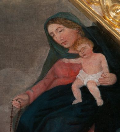 Zdjęcie nr 5: Obraz ujęty w ośmioboczną, szeroką, srebrno-złotą, ornamentalną ramę. Scena przekazania różańca św. Dominikowi przez Matkę Boską z Dzieciątkiem na tle lekko górzystego krajobrazu i zachmurzonego nieba. Święty klęczy pośrodku kompozycji, w białym habicie dominikańskim i czarnej kapie. Ręce rozłożone, lewa wyciągnięta w stronę Madonny. Głowa zwrócona w lewo. Obok niego łaciaty pies z pochodnią w pysku i niebieski glob ziemski (atrybuty świętego). Matka Boska, w czerwonej sukni i niebieskim płaszczu, siedzi w chmurach po prawej stronie kompozycji. Lekko pochylona do przodu, z prawą ręką wyciągniętą w stronę Dominika, w której trzyma różaniec. Nagie Dzieciątko, przepasane białą tkaniną, podtrzymuje lewą ręką.