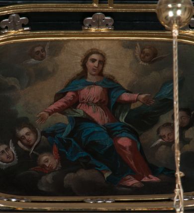 Zdjęcie nr 3: Obraz o kształcie leżącego owalu. Obraz przedstawia scenę Wniebowzięcia Najświętszej Marii Panny. Matka Boska ukazana jako siedząca na obłokach, z rozłożonymi na boki rękoma, w asyście anielskich putt, na tle obłoków i rozświetlonego  pośrodku nieba. Odziana jest w czerwoną suknię z długimi rękawami, przewiązaną w pasie, oraz niebieski płaszcz, zarzucony na ramiona i spięty na piersiach. Twarz owalna, z wydatnym nosem, okolona długimi jasnym włosami spływającymi na ramiona i plecy.  Wokół głowy gloria promienista.
