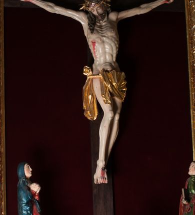 Zdjęcie nr 4: Nastawa ołtarzowa architektoniczna, jednokondygnacyjna, jednoosiowa. Pośrodku prostokątna nisza zwieńczona łukiem wklęsło-wypukłym ściętym, w bogato profilowanej, rzeźbionej i złoconej ramie zdobionej motywami roślinnymi. Nisza flankowana kolumnami o kompozytowych kapitelach, umieszczonymi na wysokich postumentach i na tle par wąskich prostokątnych płycin. Kolumny podtrzymują odcinki uproszczonego belkowania i gzyms, występujące nad podporami. Ponad gzymsem, w osiach kolumn odcinki przerwanego przyczółka. Predella zdobiona płyciną o kształcie prostokąta leżącego, z krótszymi bokami zamkniętymi łukiem nadwieszonym. We fryzie ponad kolumnami rozetki. Gzyms i naczółek zdobione akantem, rama rozetami i ornamentem roślinnym, konsole akantem i główkami puttów. Nisza ołtarza wtórnie wyłożona czerwonym aksamitem. W niej rzeźba Chrystus Ukrzyżowany. Mensa prostopadłościenna, z antepedium ujętym profilowaną ramą i zdobionym ukośną kratką, z motywami Arma Christi pośrodku oraz ażurowymi, złoconymi motywami liści w narożach. Ściany boczne ozdobione prostokątnymi płycinami. Na mensie tabernakulum drewniane, prostopadłościenne, jednoosiowe, jednokondygnacyjne. Ściana frontowa flankowana kanelowanymi pilastrami, wspierającymi uproszczone belkowanie. Pomiędzy nimi prostokątne, jednoskrzydłowe drzwiczki, ozdobione motywem złotego kielicha ze srebrną hostią, kłosami zbóż i winoroślą.  Po bokach tabernakulum rzeźby asystencyjne Matka Boska Bolesna i Św. Jan Ewangelista, ustawione na wysokich stojakach