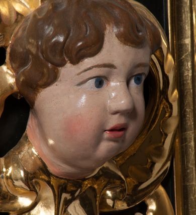 Zdjęcie nr 8: Nastawa ołtarzowa architektoniczna, jednokondygnacyjna, jednoosiowa. Pośrodku prostokątna nisza zwieńczona łukiem wklęsło-wypukłym ściętym, w bogato profilowanej, rzeźbionej i złoconej ramie zdobionej motywami roślinnymi. Nisza flankowana kolumnami o kompozytowych kapitelach, umieszczonymi na wysokich postumentach i na tle par wąskich prostokątnych płycin. Kolumny podtrzymują odcinki uproszczonego belkowania i gzyms, występujące nad podporami. Ponad gzymsem, w osiach kolumn odcinki przerwanego przyczółka. Predella zdobiona płyciną o kształcie prostokąta leżącego, z krótszymi bokami zamkniętymi łukiem nadwieszonym. We fryzie ponad kolumnami rozetki. Gzyms i naczółek zdobione akantem, rama rozetami i ornamentem roślinnym, konsole akantem i główkami puttów. Nisza ołtarza wtórnie wyłożona czerwonym aksamitem. W niej rzeźba Chrystus Ukrzyżowany. Mensa prostopadłościenna, z antepedium ujętym profilowaną ramą i zdobionym ukośną kratką, z motywami Arma Christi pośrodku oraz ażurowymi, złoconymi motywami liści w narożach. Ściany boczne ozdobione prostokątnymi płycinami. Na mensie tabernakulum drewniane, prostopadłościenne, jednoosiowe, jednokondygnacyjne. Ściana frontowa flankowana kanelowanymi pilastrami, wspierającymi uproszczone belkowanie. Pomiędzy nimi prostokątne, jednoskrzydłowe drzwiczki, ozdobione motywem złotego kielicha ze srebrną hostią, kłosami zbóż i winoroślą.  Po bokach tabernakulum rzeźby asystencyjne Matka Boska Bolesna i Św. Jan Ewangelista, ustawione na wysokich stojakach