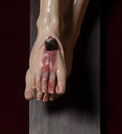 Zdjęcie nr 11: Chrystus, w typie Christo morto, rozpięty na drewnianym, prostym krzyżu łacińskim z titulusem z napisem INRI ujętym małżowiną. Chrystus przybity trzema gwoździami, w lekkim zwisie ciała i nogami ugiętymi w kolanach, ze stopami założonymi prawa na lewą. Na biodrach złocone, pofałdowane perizonium przytrzymywany sznurem; prawe biodro odsłonięte. Ciało smukłe, szczupłe, z wyraźnie zaznaczoną muskulaturą, ścięgnami i żebrami. Karnacja jasna ze strużkami krwi wypływającymi z ran. Głowa w koronie cierniowej, opuszczona i przechylona na prawy bark. Oczy zamknięte. Włosy brązowe, długie, kręcone, broda o rozdwojonych końcach. Na głowie korona cierniowa.