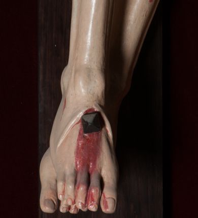 Zdjęcie nr 12: Chrystus, w typie Christo morto, rozpięty na drewnianym, prostym krzyżu łacińskim z titulusem z napisem INRI ujętym małżowiną. Chrystus przybity trzema gwoździami, w lekkim zwisie ciała i nogami ugiętymi w kolanach, ze stopami założonymi prawa na lewą. Na biodrach złocone, pofałdowane perizonium przytrzymywany sznurem; prawe biodro odsłonięte. Ciało smukłe, szczupłe, z wyraźnie zaznaczoną muskulaturą, ścięgnami i żebrami. Karnacja jasna ze strużkami krwi wypływającymi z ran. Głowa w koronie cierniowej, opuszczona i przechylona na prawy bark. Oczy zamknięte. Włosy brązowe, długie, kręcone, broda o rozdwojonych końcach. Na głowie korona cierniowa.