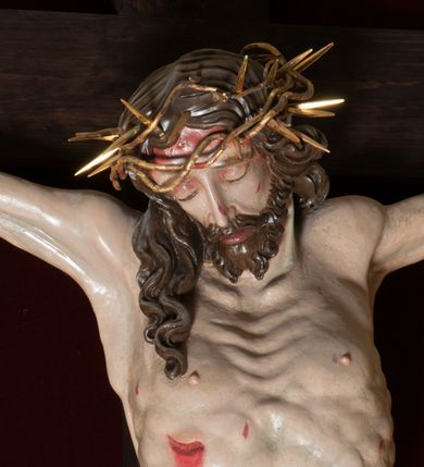 Zdjęcie nr 3: Chrystus, w typie Christo morto, rozpięty na drewnianym, prostym krzyżu łacińskim z titulusem z napisem INRI ujętym małżowiną. Chrystus przybity trzema gwoździami, w lekkim zwisie ciała i nogami ugiętymi w kolanach, ze stopami założonymi prawa na lewą. Na biodrach złocone, pofałdowane perizonium przytrzymywany sznurem; prawe biodro odsłonięte. Ciało smukłe, szczupłe, z wyraźnie zaznaczoną muskulaturą, ścięgnami i żebrami. Karnacja jasna ze strużkami krwi wypływającymi z ran. Głowa w koronie cierniowej, opuszczona i przechylona na prawy bark. Oczy zamknięte. Włosy brązowe, długie, kręcone, broda o rozdwojonych końcach. Na głowie korona cierniowa.