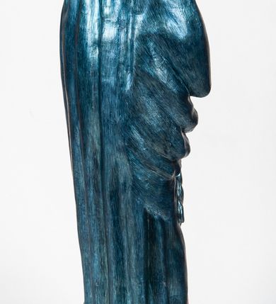 Zdjęcie nr 7: Rzeźba pełnoplastyczna, ukazująca Matkę Boską Bolesną w całej postaci. Matka Boska stoi w lekkim kontrapoście, ciężar ciała wspierając na prawej nodze, z dłońmi splecionymi na wysokości piersi w modlitewnym geście, z głową lekko odchyloną do tyłu i wzrokiem skierowanym ku górze. Twarz potraktowana schematycznie. Maria ubrana w czerwoną suknię przepasaną brązowym sznurem i niebieski płaszcz założony na głowę i barki, podtrzymywany z przodu przedramionami. Wokół szyi biała chusta.