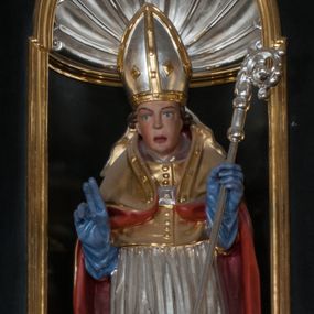 Zdjęcie nr 1: Rzeźba pełnoplastyczna, przeznaczona do umieszczenia w niszy, przedstawienie świętego w całej postaci umieszczone na niskim postumencie. Św. Stanisław ukazany jest frontalnie, w pozycji stojącej, w kontrapoście, z głową lekko pochyloną do przodu. Ręce ugięte w łokciach - w lewej pastorał, prawą wykonuje gest błogosławieństwa. Twarz pociągła, łukowato wygięte brwi, oczy szeroko otwarte, nos prosty, usta lekko rozchylone. Na głowie srebrno-złota infuła, spod której widoczne pukle kręconych włosów. Święty odziany jest w złotą kapę z czerwoną podszewką, spiętą na piersi fibulą, złoty mucet, rokietę, złotą albę, błękitne rękawiczki i brązowe buty. Rokieta fałdowana głęboko ciętymi, cienkimi, pionowymi fałdami, z jedną łukowato wygiętą fałdą. Alba z fałdami na kształt cienkich rurek, załamujących się u podstawy. Przy podstawie niewielka postać powstającego z grobu Piotrowina. Mężczyzna ukazany w trzech czwartych, zwrócony w lewo, z głową uniesioną w stronę świętego, prawą ręką na piersi, lewą wyprostowaną. Nogi ugięte w kolanach. Twarz pociągłą z wąsami. Włosy brązowe, krótkie, kręcone. Przepasany białą tkaniną, z ukośnymi, głęboko ciętymi fałdami.