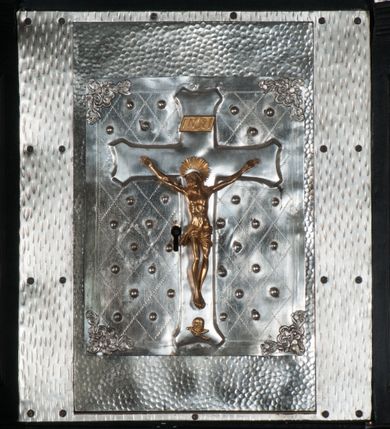 Zdjęcie nr 12: Tabernakulum na rzucie połowy ośmioboku, architektoniczne, na niskim postumencie, trójosiowe, dwudzielne (z wydzieloną gzymsem częścią cokołową), artykułowane kolumienkami o kapitelach kompozytowych oraz wolutami podtrzymującymi kompozytowe kapitele, na wybrzuszonych, zdwojonych cokołach. Belkowanie występujące nad podporami. Ścianka z drzwiczkami zamknięta łukiem półkolistym. Cokoliki, fryz i boczne ścianki tabernakulum zdobione suchym akantem. Drzwiczki jednoskrzydłowe (nowsze, pierwotne dwuskrzydłowe), srebrne, zdobione prostokątną płyciną, z romboidalnymi polami i spłaszczonymi kulami. W narożach stylizowany ornament roślinny. W centrum przedstawienie Chrystusa na krzyżu. Pola bocznych ścianek zdobione imitującymi szufladki mozaikowymi płycinami z różnobarwnych marmurów przedstawiającymi pejzaż z elementami architektury oraz płycinami wykładanymi jasnym drewnem. Pejzażowe płyciny w górnej części tabernakulum ujęte srebrnymi, odlewanymi i cyzelowanym ramkami. 
Na tabernakulum umieszczone antytetycznie rzeźby dwóch aniołów: pełnoplastyczne, w ujęciu całopostaciowym, wolnostojące. Anioł po lewej stronie ukazany jest w pozycji klęczącej, z profilu, pochylony do przodu. W rękach trzyma łódkę na kadzidło. Włosy brązowe, falowane, sięgające do ramion. Twarz pociągła, łukowato wygięte brwi, szeroko otwarte oczy, prosty nos, róż na policzkach. Skrzydła złote. Anioł odziany jest białą tunikę, z krótkimi rękawami i z cienkimi, pionowymi fałdami, załamującymi się na wysokości kolan. Stopy bose. Anioł po prawej ukazany jest w pozycji klęczącej, z profilu, pochylony do przodu. W rękach trzyma trybularz. Włosy brązowe, falowane, sięgające do ramion. Twarz pociągła, łukowato wygięte brwi, szeroko otwarte oczy, prosty nos, róż na policzkach. Skrzydła złote. Anioł odziany jest białą tunikę, z krótkimi rękawami i z cienkimi, pionowymi fałdami, załamującymi się na wysokości kolan. Stopy bose.