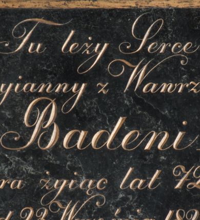 Zdjęcie nr 1: łyta w kształcie leżącego prostokąta z minuskułową inskrypcją złoconymi ozdobnymi literami: Tu leży Serce / Maryianny z Wawrzeckich / Badeni / która żyjąc lat 72. / zmarła d. 23. Września 1828. Roku / prosi o Westchnienie. Inskrypcja w prostokątnym złoconym obramieniu.
