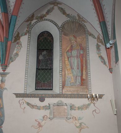 Zdjęcie nr 36: Sklepienie: żebra ozdobione na przemian pasami w kolorach czerwonym i niebieskim. Na gładkich zwornikach malowane tarcze herbowe od wschodu: Gryf i Łabędź. Wysklepki malowane wzdłuż żeber ornamentem geometrycznym złożonym z półkoli, zakończonych liliami heraldycznymi. Ze zworników rozchodzi się wić roślinna.
Ściana północna: przęsło wschodnie - trzy sceny podzielone na dwie strefy, zamknięte arkadami wspartymi na tralkach. W dolnej: klęczący św. Grzegorz, pod arkadą, na tle tkaniny; w kolejnej postać klęczącej kobiety przed sceną zstąpienia Chrystusa do piekieł (?). W górnej strefie św. Grzegorz klęczący przed trzema mężczyznami zgrupowanymi wokół stołu, którzy pokazują świętemu tkaninę. Przęsło zachodnie: scena podzielone na dwie strefy. W dolnej scena wielofiguralna, przedstawiająca ucztę ze św. Grzegorzem z gołębicą na ramieniu, siedzącym po środku stołu, oraz z pochylającym się ku niemu aniołem. Zamykają ją trzy arkady. W górnej scena eucharystyczna ze św. Grzegorzem i diakonem, klęczącymi przed ołtarzem, na którym stoi Chrystus na tle niszy. Całość zamknięta arkadą. Łuk arkady prowadzącej do kruchty podkreślony bordiurą z ornamentem plecionkowym, ujęty kandelabrami dźwigającymi gzyms. W przyłuczach dwie uskrzydlone główki anielskie. Ściana południowa: W obu przęsłach analogicznie do okien malowane iluzjonistyczne nisze konchowe z postaciami świętych na postumentach w górnej strefie ściany. W podłuczach arkad girlandy, podtrzymywane przez uskrzydlone główki anielskie. Nisze i okna obwiedzione bordiurą z ornamentem geometrycznym, podtrzymane wspólnym parapetem z podwieszoną girlandą kwiatową. Pod wspornikiem malowana kolumna utworzona z dwóch tralek. W prześle wschodnim: postać św. Wojciecha, z malowaną na postumencie inskrypcją: ŚW. WOJCIECH / PIERWSZY MĘCZNNIK POLSKI. W przęśle zachodnim: postać św. Stanisława biskupa z półpostacią Piotrowina z prawej strony. Na postumencie malowana inskrypcja: W 700-LECIE KANONIZACJI / ŚW. STANISŁAWA BP-A KRAKOWSKIEGO / 1253 – 1953.W dolnej strefie ściany epitafia ujmuje dekoracja. Epitafium Jacka Konstantyna Chościaka Popiela: stylizowane dekoracja roślinna z falującymi wstęgami; tablica pamiątkowa podtrzymywana przez putta. Łuk tęczowy od strony prezbiterium obwiedziony analogicznym do sklepienia geometrycznym ornamentem. Kolorystyka pastelowa, z silnymi akcentami błękitu, czerwieni i żółcieni.