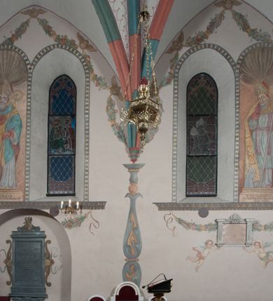 Zdjęcie nr 38: Sklepienie: żebra ozdobione na przemian pasami w kolorach czerwonym i niebieskim. Na gładkich zwornikach malowane tarcze herbowe od wschodu: Gryf i Łabędź. Wysklepki malowane wzdłuż żeber ornamentem geometrycznym złożonym z półkoli, zakończonych liliami heraldycznymi. Ze zworników rozchodzi się wić roślinna.
Ściana północna: przęsło wschodnie - trzy sceny podzielone na dwie strefy, zamknięte arkadami wspartymi na tralkach. W dolnej: klęczący św. Grzegorz, pod arkadą, na tle tkaniny; w kolejnej postać klęczącej kobiety przed sceną zstąpienia Chrystusa do piekieł (?). W górnej strefie św. Grzegorz klęczący przed trzema mężczyznami zgrupowanymi wokół stołu, którzy pokazują świętemu tkaninę. Przęsło zachodnie: scena podzielone na dwie strefy. W dolnej scena wielofiguralna, przedstawiająca ucztę ze św. Grzegorzem z gołębicą na ramieniu, siedzącym po środku stołu, oraz z pochylającym się ku niemu aniołem. Zamykają ją trzy arkady. W górnej scena eucharystyczna ze św. Grzegorzem i diakonem, klęczącymi przed ołtarzem, na którym stoi Chrystus na tle niszy. Całość zamknięta arkadą. Łuk arkady prowadzącej do kruchty podkreślony bordiurą z ornamentem plecionkowym, ujęty kandelabrami dźwigającymi gzyms. W przyłuczach dwie uskrzydlone główki anielskie. Ściana południowa: W obu przęsłach analogicznie do okien malowane iluzjonistyczne nisze konchowe z postaciami świętych na postumentach w górnej strefie ściany. W podłuczach arkad girlandy, podtrzymywane przez uskrzydlone główki anielskie. Nisze i okna obwiedzione bordiurą z ornamentem geometrycznym, podtrzymane wspólnym parapetem z podwieszoną girlandą kwiatową. Pod wspornikiem malowana kolumna utworzona z dwóch tralek. W prześle wschodnim: postać św. Wojciecha, z malowaną na postumencie inskrypcją: ŚW. WOJCIECH / PIERWSZY MĘCZNNIK POLSKI. W przęśle zachodnim: postać św. Stanisława biskupa z półpostacią Piotrowina z prawej strony. Na postumencie malowana inskrypcja: W 700-LECIE KANONIZACJI / ŚW. STANISŁAWA BP-A KRAKOWSKIEGO / 1253 – 1953.W dolnej strefie ściany epitafia ujmuje dekoracja. Epitafium Jacka Konstantyna Chościaka Popiela: stylizowane dekoracja roślinna z falującymi wstęgami; tablica pamiątkowa podtrzymywana przez putta. Łuk tęczowy od strony prezbiterium obwiedziony analogicznym do sklepienia geometrycznym ornamentem. Kolorystyka pastelowa, z silnymi akcentami błękitu, czerwieni i żółcieni.