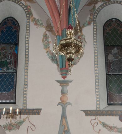 Zdjęcie nr 37: Sklepienie: żebra ozdobione na przemian pasami w kolorach czerwonym i niebieskim. Na gładkich zwornikach malowane tarcze herbowe od wschodu: Gryf i Łabędź. Wysklepki malowane wzdłuż żeber ornamentem geometrycznym złożonym z półkoli, zakończonych liliami heraldycznymi. Ze zworników rozchodzi się wić roślinna.
Ściana północna: przęsło wschodnie - trzy sceny podzielone na dwie strefy, zamknięte arkadami wspartymi na tralkach. W dolnej: klęczący św. Grzegorz, pod arkadą, na tle tkaniny; w kolejnej postać klęczącej kobiety przed sceną zstąpienia Chrystusa do piekieł (?). W górnej strefie św. Grzegorz klęczący przed trzema mężczyznami zgrupowanymi wokół stołu, którzy pokazują świętemu tkaninę. Przęsło zachodnie: scena podzielone na dwie strefy. W dolnej scena wielofiguralna, przedstawiająca ucztę ze św. Grzegorzem z gołębicą na ramieniu, siedzącym po środku stołu, oraz z pochylającym się ku niemu aniołem. Zamykają ją trzy arkady. W górnej scena eucharystyczna ze św. Grzegorzem i diakonem, klęczącymi przed ołtarzem, na którym stoi Chrystus na tle niszy. Całość zamknięta arkadą. Łuk arkady prowadzącej do kruchty podkreślony bordiurą z ornamentem plecionkowym, ujęty kandelabrami dźwigającymi gzyms. W przyłuczach dwie uskrzydlone główki anielskie. Ściana południowa: W obu przęsłach analogicznie do okien malowane iluzjonistyczne nisze konchowe z postaciami świętych na postumentach w górnej strefie ściany. W podłuczach arkad girlandy, podtrzymywane przez uskrzydlone główki anielskie. Nisze i okna obwiedzione bordiurą z ornamentem geometrycznym, podtrzymane wspólnym parapetem z podwieszoną girlandą kwiatową. Pod wspornikiem malowana kolumna utworzona z dwóch tralek. W prześle wschodnim: postać św. Wojciecha, z malowaną na postumencie inskrypcją: ŚW. WOJCIECH / PIERWSZY MĘCZNNIK POLSKI. W przęśle zachodnim: postać św. Stanisława biskupa z półpostacią Piotrowina z prawej strony. Na postumencie malowana inskrypcja: W 700-LECIE KANONIZACJI / ŚW. STANISŁAWA BP-A KRAKOWSKIEGO / 1253 – 1953.W dolnej strefie ściany epitafia ujmuje dekoracja. Epitafium Jacka Konstantyna Chościaka Popiela: stylizowane dekoracja roślinna z falującymi wstęgami; tablica pamiątkowa podtrzymywana przez putta. Łuk tęczowy od strony prezbiterium obwiedziony analogicznym do sklepienia geometrycznym ornamentem. Kolorystyka pastelowa, z silnymi akcentami błękitu, czerwieni i żółcieni.