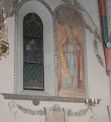 Zdjęcie nr 39: Sklepienie: żebra ozdobione na przemian pasami w kolorach czerwonym i niebieskim. Na gładkich zwornikach malowane tarcze herbowe od wschodu: Gryf i Łabędź. Wysklepki malowane wzdłuż żeber ornamentem geometrycznym złożonym z półkoli, zakończonych liliami heraldycznymi. Ze zworników rozchodzi się wić roślinna.
Ściana północna: przęsło wschodnie - trzy sceny podzielone na dwie strefy, zamknięte arkadami wspartymi na tralkach. W dolnej: klęczący św. Grzegorz, pod arkadą, na tle tkaniny; w kolejnej postać klęczącej kobiety przed sceną zstąpienia Chrystusa do piekieł (?). W górnej strefie św. Grzegorz klęczący przed trzema mężczyznami zgrupowanymi wokół stołu, którzy pokazują świętemu tkaninę. Przęsło zachodnie: scena podzielone na dwie strefy. W dolnej scena wielofiguralna, przedstawiająca ucztę ze św. Grzegorzem z gołębicą na ramieniu, siedzącym po środku stołu, oraz z pochylającym się ku niemu aniołem. Zamykają ją trzy arkady. W górnej scena eucharystyczna ze św. Grzegorzem i diakonem, klęczącymi przed ołtarzem, na którym stoi Chrystus na tle niszy. Całość zamknięta arkadą. Łuk arkady prowadzącej do kruchty podkreślony bordiurą z ornamentem plecionkowym, ujęty kandelabrami dźwigającymi gzyms. W przyłuczach dwie uskrzydlone główki anielskie. Ściana południowa: W obu przęsłach analogicznie do okien malowane iluzjonistyczne nisze konchowe z postaciami świętych na postumentach w górnej strefie ściany. W podłuczach arkad girlandy, podtrzymywane przez uskrzydlone główki anielskie. Nisze i okna obwiedzione bordiurą z ornamentem geometrycznym, podtrzymane wspólnym parapetem z podwieszoną girlandą kwiatową. Pod wspornikiem malowana kolumna utworzona z dwóch tralek. W prześle wschodnim: postać św. Wojciecha, z malowaną na postumencie inskrypcją: ŚW. WOJCIECH / PIERWSZY MĘCZNNIK POLSKI. W przęśle zachodnim: postać św. Stanisława biskupa z półpostacią Piotrowina z prawej strony. Na postumencie malowana inskrypcja: W 700-LECIE KANONIZACJI / ŚW. STANISŁAWA BP-A KRAKOWSKIEGO / 1253 – 1953.W dolnej strefie ściany epitafia ujmuje dekoracja. Epitafium Jacka Konstantyna Chościaka Popiela: stylizowane dekoracja roślinna z falującymi wstęgami; tablica pamiątkowa podtrzymywana przez putta. Łuk tęczowy od strony prezbiterium obwiedziony analogicznym do sklepienia geometrycznym ornamentem. Kolorystyka pastelowa, z silnymi akcentami błękitu, czerwieni i żółcieni.