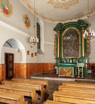 Zdjęcie nr 4: Ołtarz przyścienny, architektoniczny, jednoosiowy, jednokondygnacyjny, z uszakami. Mensa prostopadłościenna. Na niej prostopadłościenne tabernakulum zwieńczone wydatnym gzymsem, z drzwiczkami zamkniętymi łukiem nadwieszonym z motywem kielicha z hostią. Nastawa ołtarzowa ujęta korynckimi kolumnami ustawionymi na podwójnym cokole zdobionym prostokątnymi płycinami w dolnej partii i plakietami utworzonymi z ornamentu małżowinowo-chrząstkowego w górnej. Podpory dźwigają pełne, wyłamane na ich osiach belkowanie, którego gzyms jest wyniesiony nad polem centralnym. Fryz wysuniętych części dekorowany rozetami, silnie wystający gzyms zdobiony wałeczkami. Na wyłamanych częściach belkowania ustawiono symetrycznie woluty. W polu nisza zamknięta łukiem półkolistym nadwieszonym mieszcząca obraz z wielopostaciową sceną Ukrzyżowania w profilowanej ramie dekorowanej w trzech miejscach ornamentem roślinnym. Kondygnacja ujęta ażurowymi uszakami utworzonymi z suchej wici akantu. Struktura ołtarza w kolorze zielonym, trzony kolumn, detale i ornamenty złocone.