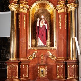 Zdjęcie nr 1: Ołtarz architektoniczny, jednoosiowy, jednokondygnacyjny ze zwieńczeniem, na podwójnym cokole. Mensa prostopadłościenna z antepedium dekorowanym płaskorzeźbionym przedstawieniem baranka Bożego leżącego na księdze i trzymającego krzyż. Na mensie tabernakulum w formie prostopadłościanu na uskokowym cokole. Na ścianie frontowej drzwi w kształcie stojącego prostokąta zamkniętego łukiem pełnym dekorowane kielichem z hostią i ujęte wicią roślinną; kondygnację wieńczy belkowanie oraz krucyfiks. Oś nastawy flankują kolumny i opilastrowane filary o kapitelach kompozytowych, ustawionych ukośnie względem lica ołtarza. W polu środkowym zamknięta półkoliście nisza dekorowana krzyżami, wypełniona rzeźbą Najświętszego Serca Jezusa. U spodu symetrycznie liście akantu. Kolumny dźwigają wyłamane belkowanie, przerwane w partii środkowej, na zewnętrznych podporach woluty, na których posadowiono figurki aniołków. Fantazyjne zwieńczenie w formie zbliżonej do stojącego prostokąta, w którym obraz z przedstawieniem widzenia św. Małgorzaty Marii Alacoque ujęty ramą utworzoną z ornamentu rocaille’owego i wstęgi, zwieńczony muszlą. 
Cokoły podpór dekorowane płycinami, trzony pilastrów ornamentem roślinnym, w partii fryzu rozety. Struktura polichromowana na kolor brązowy, ze złoconą ornamentyką i złoconymi detalami.