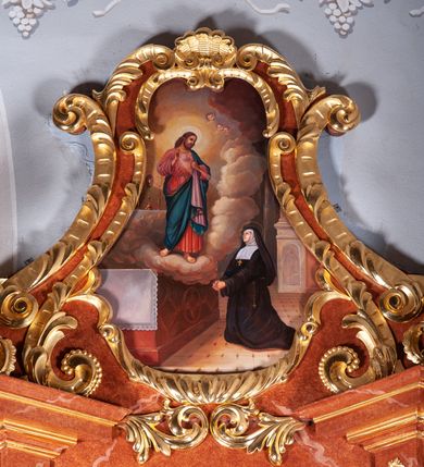 Zdjęcie nr 5: Ołtarz architektoniczny, jednoosiowy, jednokondygnacyjny ze zwieńczeniem, na podwójnym cokole. Mensa prostopadłościenna z antepedium dekorowanym płaskorzeźbionym przedstawieniem baranka Bożego leżącego na księdze i trzymającego krzyż. Na mensie tabernakulum w formie prostopadłościanu na uskokowym cokole. Na ścianie frontowej drzwi w kształcie stojącego prostokąta zamkniętego łukiem pełnym dekorowane kielichem z hostią i ujęte wicią roślinną; kondygnację wieńczy belkowanie oraz krucyfiks. Oś nastawy flankują kolumny i opilastrowane filary o kapitelach kompozytowych, ustawionych ukośnie względem lica ołtarza. W polu środkowym zamknięta półkoliście nisza dekorowana krzyżami, wypełniona rzeźbą Najświętszego Serca Jezusa. U spodu symetrycznie liście akantu. Kolumny dźwigają wyłamane belkowanie, przerwane w partii środkowej, na zewnętrznych podporach woluty, na których posadowiono figurki aniołków. Fantazyjne zwieńczenie w formie zbliżonej do stojącego prostokąta, w którym obraz z przedstawieniem widzenia św. Małgorzaty Marii Alacoque ujęty ramą utworzoną z ornamentu rocaille’owego i wstęgi, zwieńczony muszlą. 
Cokoły podpór dekorowane płycinami, trzony pilastrów ornamentem roślinnym, w partii fryzu rozety. Struktura polichromowana na kolor brązowy, ze złoconą ornamentyką i złoconymi detalami.