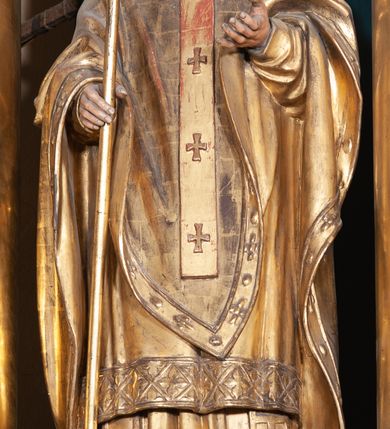 Zdjęcie nr 5: Ołtarz architektoniczny, jednoosiowy, jednokondygnacyjny ze zwieńczeniem, na podwójnym cokole. Mensa prostopadłościenna z antepedium dekorowanym płaskorzeźbionym przedstawieniem Jezusa rozdającego Komunię Świętą. Tabernakulum złożone z prostopadłościennej, obitej blachą skrzynki z drzwiczkami dekorowanymi literami „A” i „Ω” w górnej części i tablicami Dekalogu i otwartą księgą w dolnej, ujętymi winną latoroślą. Skrzynkę flankują prostopadłościany dekorowane na frontowych ściankach symbolami wiary i narzędziami męki, na których umieszczono klęczące, modlące się anioły. Między nimi ustawiono tron wystawienia w formie kolejnego prostopadłościanu, w którego frontowej ścianie znajduje się nisza wyłożona kratką z rozetami i ujęta dekoracją złożoną z księgi, tablic 10 przykazań i winnej latorośli.  Tron wystawienia zwieńczony gzymsem i postaciami dwóch aniołów, które klęczą i pochylają się w modlitewnych gestach. Oś nastawy flankują na przemian dwie pary pilastrów i dwie pary kolumn o kapitelach kompozytowych, ustawionych ukośnie względem lica ołtarza. Pomiędzy nimi znajdują się cztery figury (od lewej): św. Wojciecha, św. Jana Kantego, św. Kazimierza Jagiellończyka i św. Stanisława. W polu środkowym obraz z przedstawieniem świętych patronów Szymona i Judy Tadeusza w formie stojącego prostokąta zamkniętego łukiem odcinkowym w profilowanej, złoconej ramie ozdobionej rocaille’em. U spodu dwie ornamentalne ramki z motywem winnego grona z kluczami Piotrowymi po prawej i krzyżem ze stułą i lilią, po lewej. Kolumny dźwigają wyłamane belkowanie, przerwane w partii środkowej. Górną partię belkowania na osiach kolumn wieńczą putta posadowione na wolutach. Cokół dekorowany płycinami z rocaille’em, trzony pilastrów festonami utworzonymi z wstęgi i kiści winnego grona. W partii fryzu płyciny z rozetami. Fantazyjne zwieńczenie w formie zbliżonej do stojącego prostokąta. W nim, na obłoku półpostać błogosławiącego Boga Ojca w trójkątnym nimbie, z jabłkiem królewskim w formie globu zwieńczonego krzyżem w lewej dłoni. Poniżej gołębica Ducha Świętego w glorii promienistej. Kondygnacje od zwieńczenia oddziela kartusz utworzony z ornamentu rocaille’owego i wstęgi. Struktura polichromowana na kolor ciemnoniebieski, ze złoconą ornamentyką i złoconymi i srebrzonymi detalami.