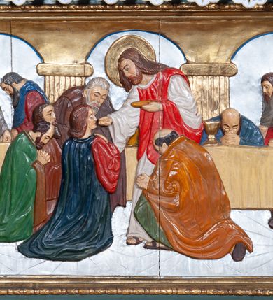 Zdjęcie nr 13: Ołtarz architektoniczny, jednoosiowy, jednokondygnacyjny ze zwieńczeniem, na podwójnym cokole. Mensa prostopadłościenna z antepedium dekorowanym płaskorzeźbionym przedstawieniem Jezusa rozdającego Komunię Świętą. Tabernakulum złożone z prostopadłościennej, obitej blachą skrzynki z drzwiczkami dekorowanymi literami „A” i „Ω” w górnej części i tablicami Dekalogu i otwartą księgą w dolnej, ujętymi winną latoroślą. Skrzynkę flankują prostopadłościany dekorowane na frontowych ściankach symbolami wiary i narzędziami męki, na których umieszczono klęczące, modlące się anioły. Między nimi ustawiono tron wystawienia w formie kolejnego prostopadłościanu, w którego frontowej ścianie znajduje się nisza wyłożona kratką z rozetami i ujęta dekoracją złożoną z księgi, tablic 10 przykazań i winnej latorośli.  Tron wystawienia zwieńczony gzymsem i postaciami dwóch aniołów, które klęczą i pochylają się w modlitewnych gestach. Oś nastawy flankują na przemian dwie pary pilastrów i dwie pary kolumn o kapitelach kompozytowych, ustawionych ukośnie względem lica ołtarza. Pomiędzy nimi znajdują się cztery figury (od lewej): św. Wojciecha, św. Jana Kantego, św. Kazimierza Jagiellończyka i św. Stanisława. W polu środkowym obraz z przedstawieniem świętych patronów Szymona i Judy Tadeusza w formie stojącego prostokąta zamkniętego łukiem odcinkowym w profilowanej, złoconej ramie ozdobionej rocaille’em. U spodu dwie ornamentalne ramki z motywem winnego grona z kluczami Piotrowymi po prawej i krzyżem ze stułą i lilią, po lewej. Kolumny dźwigają wyłamane belkowanie, przerwane w partii środkowej. Górną partię belkowania na osiach kolumn wieńczą putta posadowione na wolutach. Cokół dekorowany płycinami z rocaille’em, trzony pilastrów festonami utworzonymi z wstęgi i kiści winnego grona. W partii fryzu płyciny z rozetami. Fantazyjne zwieńczenie w formie zbliżonej do stojącego prostokąta. W nim, na obłoku półpostać błogosławiącego Boga Ojca w trójkątnym nimbie, z jabłkiem królewskim w formie globu zwieńczonego krzyżem w lewej dłoni. Poniżej gołębica Ducha Świętego w glorii promienistej. Kondygnacje od zwieńczenia oddziela kartusz utworzony z ornamentu rocaille’owego i wstęgi. Struktura polichromowana na kolor ciemnoniebieski, ze złoconą ornamentyką i złoconymi i srebrzonymi detalami.