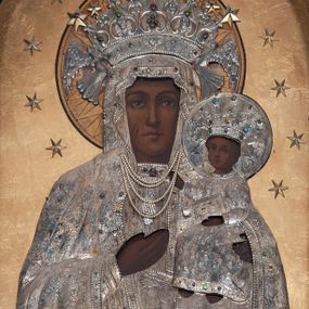 Zdjęcie nr 1: Obraz w formie stojącego prostokąta zamkniętego łukiem pełnym z przedstawieniem Matki Boskiej w typie Częstochowskiej. Maria została ukazana frontalnie, w półpostaci. Patrzy na widza, twarz ma owalną, o wyrazistych rysach, ciemnej karnacji, długim nosie, ciemnych oczach i niewielkich ustach. Prawą ręka wskazuje na trzymane na lewej ręce Dzieciątko Jezus zwrócone w trzech czwartych w prawo, z głową odwróconą do widza. Twarz ma okrągłą, o ciemnej karnacji i wyrazistych rysach, na prawym policzku dwa nacięcia. Włosy brązowe, kręcone, zaczesane na twarz. Lewą rączką podtrzymuje księgę, prawą ma uniesioną w geście błogosławieństwa. Ubrania postaci oraz nimby i korony wykonane są ze srebrnej blachy, trybowanej w ornament roślinny, podkreślonej perełkowaniem na krawędziach i kameryzowanej w partii lamowań oraz koron. Maria ma pod szyją zawieszone sznury pereł. Nimb Dzieciątka jest wykonany z blachy, Marii złocony, oba promieniste. Obie postacie mają otwarte korony przytrzymywane przez niewielkie anioły; koronę Marii dekoruje dodatkowo pięć płaskorzeźbionych, złoconych gwiazd. Wokół głów obu postaci 12 gwiazd, tło jednolite – złote. 