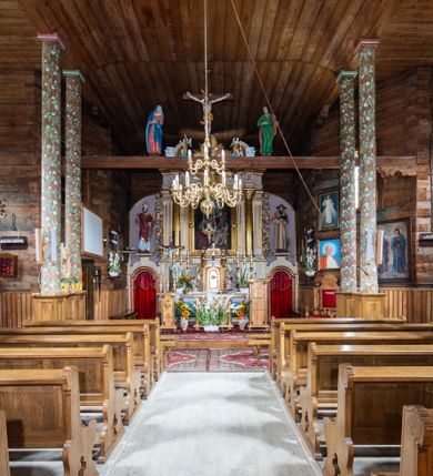 Zdjęcie nr 14: Nastawa ołtarzowa architektoniczna, jednoosiowa z bramkami, jednokondygnacyjna. Ołtarz drewniany, prostopadłościenny. Mensa drewniana z silnie wysuniętym, profilowanym brzegiem. Antependium ujęte grubą ramą, w polu obraz w formie wydłużonego, leżącego prostokąta z przedstawieniem Chrztu Chrystusa. 
Tabernakulum w formie dużej, prostopadłościennej skrzynki ujętej w przednich narożach pilastrami dźwigającymi profilowany, trójbocznie wyłamany gzyms, dekorowany u spodu kostkowaniem i uskrzydloną główką anielską u szczytu. Drzwiczki w formie stojącego prostokąta zamkniętego łukiem półkolistym, ujęte opaską i rzeźbioną ramą; w polu medalion w glorii promienistej z płaskorzeźbioną postacią Dzieciątka na obłoku. Drzwiczki ujęte podwieszonymi na wstędze festonami utworzonymi z winnego grona, kłosów zbóż i kampanuli. Tabernakulum flankowane uszami z karbowanych wolut i liści palmowych; zwieńczone cokołem, na którym stoi równoramienny krzyż o trójlistnym zakończeniu ramion, na ich skrzyżowaniu medalion z Okiem Opatrzności w glorii. Na gzymsie, na osi pilastrów dwie klęczące figury adorujących aniołów. Przed tabernakulum druga para klęczących aniołów trzymających kwieciste girlandy.

Retabulum na wysokim cokole zryzalitowanym przy brzegach; ujęte parą zwielokrotnionych pilastrów o kanelowanych trzonach i stojącą przed nimi parą kolumn o kapitelach kompozytowych. Podpory dźwigają pełne belkowanie, wyłamane na ich osi, przerwane glorią nad polem środkowym oraz przerwany falisty przyczółek. W polu środkowym płytka nisza w formie stojącego prostokąta o wklęsłych górnych narożach, ujęta profilowaną ramą z obrazem Święta Rodzina. Na zasuwie obrazy: Mistyczne Zaślubiny Św. Katarzyny oraz  Najświętsza Maria Panna Niepokalanie Poczęta. W polu belkowania gloria promienista, w której centrum rzeźbione przedstawienie Baranka Apokaliptycznego na księdze, w otoczeniu obłoków, nad nim Gołębica Ducha Świętego; u spodu flankowana dwoma rzeźbami puttów. Bramki z przejściami w formie stojącego prostokąta zamkniętego łukiem półkolistym nadwieszonym, ujęte profilowanymi ramami. Ponad szczyty o fantazyjnym wykroju, tworzące postumenty dla figur św. Augustyna po lewej stronie i św. Hieronima po prawej. Cokół i ryzality dekorowane płycinami, od frontu z ornamentem roślinnym. Rama dekorowana trzema muszlami; w przyłuczach uskrzydlone główki anielskie. W partii fryzu, na osi kolumn rozety. Kondygnacja ujęta uszami utworzonymi z suchego akantu. Struktura polichromowana w kolorze beżowym, detal na czerwono, kolumny, gloria, ornamentyka i profile złocone.