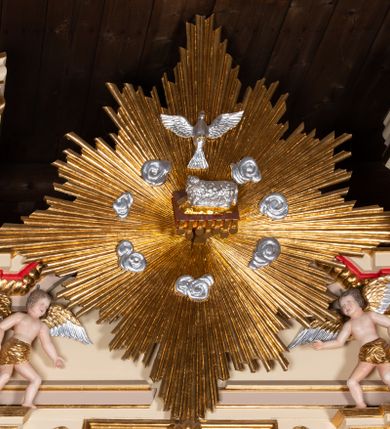 Zdjęcie nr 3: Nastawa ołtarzowa architektoniczna, jednoosiowa z bramkami, jednokondygnacyjna. Ołtarz drewniany, prostopadłościenny. Mensa drewniana z silnie wysuniętym, profilowanym brzegiem. Antependium ujęte grubą ramą, w polu obraz w formie wydłużonego, leżącego prostokąta z przedstawieniem Chrztu Chrystusa. 
Tabernakulum w formie dużej, prostopadłościennej skrzynki ujętej w przednich narożach pilastrami dźwigającymi profilowany, trójbocznie wyłamany gzyms, dekorowany u spodu kostkowaniem i uskrzydloną główką anielską u szczytu. Drzwiczki w formie stojącego prostokąta zamkniętego łukiem półkolistym, ujęte opaską i rzeźbioną ramą; w polu medalion w glorii promienistej z płaskorzeźbioną postacią Dzieciątka na obłoku. Drzwiczki ujęte podwieszonymi na wstędze festonami utworzonymi z winnego grona, kłosów zbóż i kampanuli. Tabernakulum flankowane uszami z karbowanych wolut i liści palmowych; zwieńczone cokołem, na którym stoi równoramienny krzyż o trójlistnym zakończeniu ramion, na ich skrzyżowaniu medalion z Okiem Opatrzności w glorii. Na gzymsie, na osi pilastrów dwie klęczące figury adorujących aniołów. Przed tabernakulum druga para klęczących aniołów trzymających kwieciste girlandy.

Retabulum na wysokim cokole zryzalitowanym przy brzegach; ujęte parą zwielokrotnionych pilastrów o kanelowanych trzonach i stojącą przed nimi parą kolumn o kapitelach kompozytowych. Podpory dźwigają pełne belkowanie, wyłamane na ich osi, przerwane glorią nad polem środkowym oraz przerwany falisty przyczółek. W polu środkowym płytka nisza w formie stojącego prostokąta o wklęsłych górnych narożach, ujęta profilowaną ramą z obrazem Święta Rodzina. Na zasuwie obrazy: Mistyczne Zaślubiny Św. Katarzyny oraz  Najświętsza Maria Panna Niepokalanie Poczęta. W polu belkowania gloria promienista, w której centrum rzeźbione przedstawienie Baranka Apokaliptycznego na księdze, w otoczeniu obłoków, nad nim Gołębica Ducha Świętego; u spodu flankowana dwoma rzeźbami puttów. Bramki z przejściami w formie stojącego prostokąta zamkniętego łukiem półkolistym nadwieszonym, ujęte profilowanymi ramami. Ponad szczyty o fantazyjnym wykroju, tworzące postumenty dla figur św. Augustyna po lewej stronie i św. Hieronima po prawej. Cokół i ryzality dekorowane płycinami, od frontu z ornamentem roślinnym. Rama dekorowana trzema muszlami; w przyłuczach uskrzydlone główki anielskie. W partii fryzu, na osi kolumn rozety. Kondygnacja ujęta uszami utworzonymi z suchego akantu. Struktura polichromowana w kolorze beżowym, detal na czerwono, kolumny, gloria, ornamentyka i profile złocone.