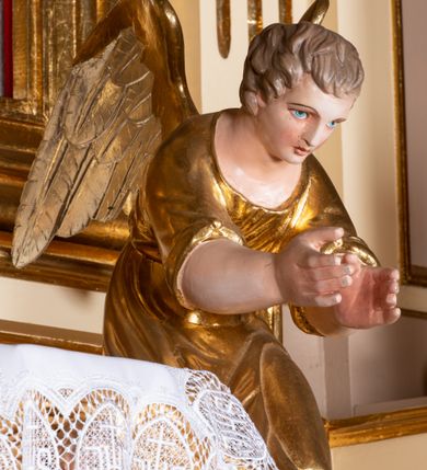 Zdjęcie nr 9: Nastawa ołtarzowa architektoniczna, jednoosiowa z bramkami, jednokondygnacyjna. Ołtarz drewniany, prostopadłościenny. Mensa drewniana z silnie wysuniętym, profilowanym brzegiem. Antependium ujęte grubą ramą, w polu obraz w formie wydłużonego, leżącego prostokąta z przedstawieniem Chrztu Chrystusa. 
Tabernakulum w formie dużej, prostopadłościennej skrzynki ujętej w przednich narożach pilastrami dźwigającymi profilowany, trójbocznie wyłamany gzyms, dekorowany u spodu kostkowaniem i uskrzydloną główką anielską u szczytu. Drzwiczki w formie stojącego prostokąta zamkniętego łukiem półkolistym, ujęte opaską i rzeźbioną ramą; w polu medalion w glorii promienistej z płaskorzeźbioną postacią Dzieciątka na obłoku. Drzwiczki ujęte podwieszonymi na wstędze festonami utworzonymi z winnego grona, kłosów zbóż i kampanuli. Tabernakulum flankowane uszami z karbowanych wolut i liści palmowych; zwieńczone cokołem, na którym stoi równoramienny krzyż o trójlistnym zakończeniu ramion, na ich skrzyżowaniu medalion z Okiem Opatrzności w glorii. Na gzymsie, na osi pilastrów dwie klęczące figury adorujących aniołów. Przed tabernakulum druga para klęczących aniołów trzymających kwieciste girlandy.

Retabulum na wysokim cokole zryzalitowanym przy brzegach; ujęte parą zwielokrotnionych pilastrów o kanelowanych trzonach i stojącą przed nimi parą kolumn o kapitelach kompozytowych. Podpory dźwigają pełne belkowanie, wyłamane na ich osi, przerwane glorią nad polem środkowym oraz przerwany falisty przyczółek. W polu środkowym płytka nisza w formie stojącego prostokąta o wklęsłych górnych narożach, ujęta profilowaną ramą z obrazem Święta Rodzina. Na zasuwie obrazy: Mistyczne Zaślubiny Św. Katarzyny oraz  Najświętsza Maria Panna Niepokalanie Poczęta. W polu belkowania gloria promienista, w której centrum rzeźbione przedstawienie Baranka Apokaliptycznego na księdze, w otoczeniu obłoków, nad nim Gołębica Ducha Świętego; u spodu flankowana dwoma rzeźbami puttów. Bramki z przejściami w formie stojącego prostokąta zamkniętego łukiem półkolistym nadwieszonym, ujęte profilowanymi ramami. Ponad szczyty o fantazyjnym wykroju, tworzące postumenty dla figur św. Augustyna po lewej stronie i św. Hieronima po prawej. Cokół i ryzality dekorowane płycinami, od frontu z ornamentem roślinnym. Rama dekorowana trzema muszlami; w przyłuczach uskrzydlone główki anielskie. W partii fryzu, na osi kolumn rozety. Kondygnacja ujęta uszami utworzonymi z suchego akantu. Struktura polichromowana w kolorze beżowym, detal na czerwono, kolumny, gloria, ornamentyka i profile złocone.