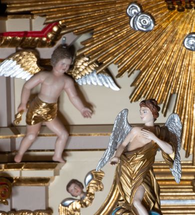 Zdjęcie nr 16: Nastawa ołtarzowa architektoniczna, jednoosiowa z bramkami, jednokondygnacyjna. Ołtarz drewniany, prostopadłościenny. Mensa drewniana z silnie wysuniętym, profilowanym brzegiem. Antependium ujęte grubą ramą, w polu obraz w formie wydłużonego, leżącego prostokąta z przedstawieniem Chrztu Chrystusa. 
Tabernakulum w formie dużej, prostopadłościennej skrzynki ujętej w przednich narożach pilastrami dźwigającymi profilowany, trójbocznie wyłamany gzyms, dekorowany u spodu kostkowaniem i uskrzydloną główką anielską u szczytu. Drzwiczki w formie stojącego prostokąta zamkniętego łukiem półkolistym, ujęte opaską i rzeźbioną ramą; w polu medalion w glorii promienistej z płaskorzeźbioną postacią Dzieciątka na obłoku. Drzwiczki ujęte podwieszonymi na wstędze festonami utworzonymi z winnego grona, kłosów zbóż i kampanuli. Tabernakulum flankowane uszami z karbowanych wolut i liści palmowych; zwieńczone cokołem, na którym stoi równoramienny krzyż o trójlistnym zakończeniu ramion, na ich skrzyżowaniu medalion z Okiem Opatrzności w glorii. Na gzymsie, na osi pilastrów dwie klęczące figury adorujących aniołów. Przed tabernakulum druga para klęczących aniołów trzymających kwieciste girlandy.

Retabulum na wysokim cokole zryzalitowanym przy brzegach; ujęte parą zwielokrotnionych pilastrów o kanelowanych trzonach i stojącą przed nimi parą kolumn o kapitelach kompozytowych. Podpory dźwigają pełne belkowanie, wyłamane na ich osi, przerwane glorią nad polem środkowym oraz przerwany falisty przyczółek. W polu środkowym płytka nisza w formie stojącego prostokąta o wklęsłych górnych narożach, ujęta profilowaną ramą z obrazem Święta Rodzina. Na zasuwie obrazy: Mistyczne Zaślubiny Św. Katarzyny oraz  Najświętsza Maria Panna Niepokalanie Poczęta. W polu belkowania gloria promienista, w której centrum rzeźbione przedstawienie Baranka Apokaliptycznego na księdze, w otoczeniu obłoków, nad nim Gołębica Ducha Świętego; u spodu flankowana dwoma rzeźbami puttów. Bramki z przejściami w formie stojącego prostokąta zamkniętego łukiem półkolistym nadwieszonym, ujęte profilowanymi ramami. Ponad szczyty o fantazyjnym wykroju, tworzące postumenty dla figur św. Augustyna po lewej stronie i św. Hieronima po prawej. Cokół i ryzality dekorowane płycinami, od frontu z ornamentem roślinnym. Rama dekorowana trzema muszlami; w przyłuczach uskrzydlone główki anielskie. W partii fryzu, na osi kolumn rozety. Kondygnacja ujęta uszami utworzonymi z suchego akantu. Struktura polichromowana w kolorze beżowym, detal na czerwono, kolumny, gloria, ornamentyka i profile złocone.