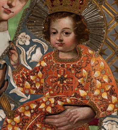 Zdjęcie nr 5: Obraz umieszczony jest w centralnej części południowego ołtarza, w prostokątnej niszy zamkniętej łukiem półkolistym. Ma kształt stojącego prostokąta, umieszczonego w profilowanej ramie. Przedstawia Matkę Boską z Dzieciątkiem siedzącym na jej ramieniu. Maria ukazana jest frontalnie, do pasa, z lekko pochyloną w lewo głową i berłem w prawej dłoni. Jej twarz jest owalna, o wyrazistych rysach, oczy duże, o wykroju migdałowym, ponad nimi brwi zarysowane gładkim łukiem. Nos prosty, usta pełne, ale niewielkie. Cera jasna, lekko zaróżowiona na policzkach. Madonna ubrana jest w biało-czerwoną haftowaną suknię i błękitny płaszcz zarzucony na głowę, pokryty motywami białych kwiatów i liści. Jezusa, którego okrągłą, pełną twarz okalają ułożone w miękkie fale włosy koloru brązowego, wyróżniają duże, migdałowe oczy, niewielki nos i drobne usta. Jest ubrany w pomarańczową suknię, na której wyhaftowane są biało-żółte kwiaty i wijące się brązowe wstęgi. Dzieciątko unosi prawą rączkę w geście błogosławieństwa, lewą dotyka dłoni matki. Na głowach Marii i Jezusa znajdują się zamknięte korony zwieńczone krzyżem, a wokół nich wytłaczane, srebrzyste nimby promieniste. Tło obrazu wykonane jest z metalowej blachy, zdobione srebrną kratką ułożoną pod kątem, ze złotymi gwiazdkami i rozetami w polach.
