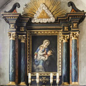 Zdjęcie nr 1: Prostopadłościenny ołtarz z retabulum posadowionym na dwustrefowym cokole. Nastawa ujęta parami kolumn, z których zewnętrzne są wysunięte do przodu, a środkowe cofnięte do tyłu, z kapitelami kompozytowymi, podtrzymującymi przełamujące się nad nimi belkowanie, z wydatnym gzymsem ozdobionym kostkowaniem. Na osi kolumn skrajnych faliste naczółki, nad częścią środkową Oko Opatrzności obramione chmurami, na tle promienistej glorii. Pośrodku nastawy prostokątny obraz w profilowanej ramie wypełnionej kwiatonami z wyobrażeniem Matki Boskiej Różańcowej i św. Dominikiem. 

