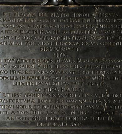 Zdjęcie nr 5: Tablica epitafijna w formie zbliżonej do kwadratu, w profilowanym obramieniu z uszakami przechodzącymi w spływy wolutowe. Nad płytą kartusz wokół owalnego, wypukłego pola z godłem herbu Dołęga. Pod płytą woluty stykają się z fartuchem. Na tablicy inskrypcja: „D(EO) O(PTIMO) M(AXIMO) / ET MAGNAE DEI MATRI HONOR AETERNVS. / PYS MANIBV(S) LONGA FELICITAS MARTINI DOBRVCHOWSKI, / CVIVS FLORE[M] AETATIS SOCIETAS IESV PER OMNES BONA/RV(M) ARTIV(M) DISCIPLINAS PIE AC FELICITER EXCOLVIT; / IVVENTVTE(M) SIGNA IMPERATORIA MAGNI EXCERCITVV(M) DVCIS / STANISLAI ZOŁKIEVII IDONEAM REBVS GERENDIS / FIRMAVERVNT. / HINC / RELIQVV(M) AETATIS ROBVR IN AVLA(M) MARTINI SZYSZKOVII: / EP(ISCOP)I CRACOVIEN(SIS). VIRIS ILLVSTRIB(US) FERACE(M) INTVLIT. / A QVO PRAEFECTVRA WAWRZYNECENSI ORNATVS EPI/SCOPALIS IN PAVPERES, ET SACROS HOMINES LIBERA/LITATIS LVCVLENTVS FVIT TESTIS, / AC FIDVS HAERES / CV(M) ET IPSE MVNIFICVS EIVS VIRTVTIS CVLTOR DE PRO/PRYS FORTVNAE BONIS PER OMNEM VITA(M) ESSET; / ANTIQVI MORIS, ET PLVRIMIS CONSPICVVS VIRTVTIBVS, / OBYT ANNO D(OMI)NI. 1640. MENSE IVNIO DIE 24 / AETATIS 5O. INGENTI OMNIBVS RELICTO / DESIDERIO SVI”.