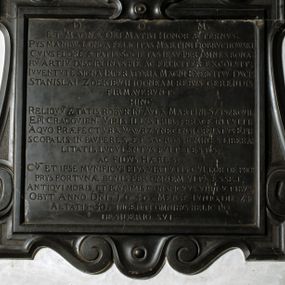 Zdjęcie nr 1: Tablica epitafijna w formie zbliżonej do kwadratu, w profilowanym obramieniu z uszakami przechodzącymi w spływy wolutowe. Nad płytą kartusz wokół owalnego, wypukłego pola z godłem herbu Dołęga. Pod płytą woluty stykają się z fartuchem. Na tablicy inskrypcja: „D(EO) O(PTIMO) M(AXIMO) / ET MAGNAE DEI MATRI HONOR AETERNVS. / PYS MANIBV(S) LONGA FELICITAS MARTINI DOBRVCHOWSKI, / CVIVS FLORE[M] AETATIS SOCIETAS IESV PER OMNES BONA/RV(M) ARTIV(M) DISCIPLINAS PIE AC FELICITER EXCOLVIT; / IVVENTVTE(M) SIGNA IMPERATORIA MAGNI EXCERCITVV(M) DVCIS / STANISLAI ZOŁKIEVII IDONEAM REBVS GERENDIS / FIRMAVERVNT. / HINC / RELIQVV(M) AETATIS ROBVR IN AVLA(M) MARTINI SZYSZKOVII: / EP(ISCOP)I CRACOVIEN(SIS). VIRIS ILLVSTRIB(US) FERACE(M) INTVLIT. / A QVO PRAEFECTVRA WAWRZYNECENSI ORNATVS EPI/SCOPALIS IN PAVPERES, ET SACROS HOMINES LIBERA/LITATIS LVCVLENTVS FVIT TESTIS, / AC FIDVS HAERES / CV(M) ET IPSE MVNIFICVS EIVS VIRTVTIS CVLTOR DE PRO/PRYS FORTVNAE BONIS PER OMNEM VITA(M) ESSET; / ANTIQVI MORIS, ET PLVRIMIS CONSPICVVS VIRTVTIBVS, / OBYT ANNO D(OMI)NI. 1640. MENSE IVNIO DIE 24 / AETATIS 5O. INGENTI OMNIBVS RELICTO / DESIDERIO SVI”.