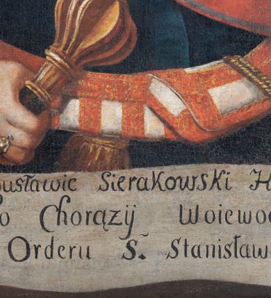 Zdjęcie nr 3: Obraz w kształcie stojącego prostokąta ujętego profilowaną, złoconą ramą. Roman Sierakowski w ujęciu półpostaciowym, na wprost, z głową skierowaną w trzech czwartych w prawo. Przedstawiony jako mężczyzna w średnim wieku. Twarz szlachcica okrągła, pełna, wysokie czoło, widoczna łysina. Oczy małe, głęboko osadzone, prosty nos, wąskie zaciśnięte usta, nad którymi czarne wąsy. Krótka szyja. Ubrany jest w białą koszulę, spiętą pod szyją fibulą. Na koszuli srebrna zbroja łuskowa dekoracyjnie zakończona pod szyją pozłacanym wiciami. Szatę wierzchnią stanowi granatowy żupan, przewiązany biało-czerwonym pasem kontuszowym, zakończonym złotą frędzlą. Do pasa, po lewej stronie  przytwierdzona za pomocą złotego plecionego sznura karabela. Lewa ręka lekko uniesiona, nie widać dłoni, zaś prawa lekko zgięta w łokciu, trzyma w niej buzdygan. Na palcu  serdecznym prawej ręki pierścień z kamieniem szlachetnym. Na lewej piersi wyszyta gwiazda orderowa, a cały żupan przepasany jest wstęgą Orderu Świętego Stanisława, w kolorach czerwonym i białym. U dołu przedstawienia banderola z napisem ,,Roman z Bogusławic Sierakowski Hrabia S(więte)go / P(aństwa) Rzymskiego Chorązy Woiewodztwa kra/kowskiego Orderu S(więte)go Stanisława Kawaler”. Na odwrociu napis „Ant(oni) Masłowski pinxit / Crac(oviae) (dies) (pri)ma (decem)bris” oraz drugi nieczytelny. 
Tło ciemne, brunatne z rozjaśnieniami wokół sylwetki  szlachcica.