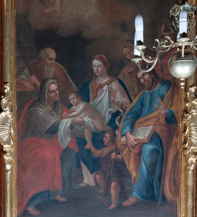 Zdjęcie nr 3: Ołtarz przyścienny, architektoniczny, z mensą w formie sarkofagu, dwustrefową, o wklęsło-wypukłych bokach. Mensa z kamiennym portatylem. Retabulum jednoosiowe, jednokondygnacyjne, ustawione na wysokim cokole, ujęte parą półfilarów kompozytowych o kanelowanych trzonach ustawionych na tle podwójnych pilastrów, z których zewnętrzne dostawione ukośnie. Podpory wspierają wyłamujące się belkowanie z architrawem wygiętym w  łuk nadwieszony nad polem środkowym i wydatnym, profilowanym gzymsem.  W zwieńczeniu przerwany, półkolisty przyczółek oraz gloria promienista z obłokami, pośrodku których aplikowany monogram maryjny. 
W polu środkowym wycięta wnęka ujęta profilowaną ramą w kształcie stojącego prostokąta, zamkniętego łukiem nadwieszonym. We wnęce obraz z przedstawieniem Świętej Rodziny, nad którym rzeźbiony kartusz formowany z ornamentu rocaille&#039;owego.
Całość struktury ołtarza malowana w kolorze ciemnobrązowym, Półfilary, fryz oraz mensa pokryte malowaną marmoryzacją w odcieniach zieleni, pole środkowe ciemnoczerwone, detal architektoniczny  i profilowania pozłacane.