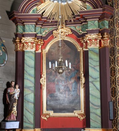 Zdjęcie nr 1: Ołtarz przyścienny, architektoniczny, z mensą w formie sarkofagu, dwustrefową, o wklęsło-wypukłych bokach. Mensa z kamiennym portatylem. Retabulum jednoosiowe, jednokondygnacyjne, ustawione na wysokim cokole, ujęte parą półfilarów kompozytowych o kanelowanych trzonach ustawionych na tle podwójnych pilastrów, z których zewnętrzne dostawione ukośnie. Podpory wspierają wyłamujące się belkowanie z architrawem wygiętym w  łuk nadwieszony nad polem środkowym i wydatnym, profilowanym gzymsem.  W zwieńczeniu przerwany, półkolisty przyczółek oraz gloria promienista z obłokami, pośrodku których aplikowany monogram maryjny. 
W polu środkowym wycięta wnęka ujęta profilowaną ramą w kształcie stojącego prostokąta, zamkniętego łukiem nadwieszonym. We wnęce obraz z przedstawieniem Świętej Rodziny, nad którym rzeźbiony kartusz formowany z ornamentu rocaille&#039;owego.
Całość struktury ołtarza malowana w kolorze ciemnobrązowym, Półfilary, fryz oraz mensa pokryte malowaną marmoryzacją w odcieniach zieleni, pole środkowe ciemnoczerwone, detal architektoniczny  i profilowania pozłacane.