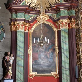 Zdjęcie nr 1: Ołtarz przyścienny, architektoniczny, z mensą w formie sarkofagu, dwustrefową, o wklęsło-wypukłych bokach. Mensa z kamiennym portatylem. Retabulum jednoosiowe, jednokondygnacyjne, ustawione na wysokim cokole, ujęte parą półfilarów kompozytowych o kanelowanych trzonach ustawionych na tle podwójnych pilastrów, z których zewnętrzne dostawione ukośnie. Podpory wspierają wyłamujące się belkowanie z architrawem wygiętym w  łuk nadwieszony nad polem środkowym i wydatnym, profilowanym gzymsem.  W zwieńczeniu przerwany, półkolisty przyczółek oraz gloria promienista z obłokami, pośrodku których aplikowany monogram maryjny. 
W polu środkowym wycięta wnęka ujęta profilowaną ramą w kształcie stojącego prostokąta, zamkniętego łukiem nadwieszonym. We wnęce obraz z przedstawieniem Świętej Rodziny, nad którym rzeźbiony kartusz formowany z ornamentu rocaille'owego.
Całość struktury ołtarza malowana w kolorze ciemnobrązowym, Półfilary, fryz oraz mensa pokryte malowaną marmoryzacją w odcieniach zieleni, pole środkowe ciemnoczerwone, detal architektoniczny  i profilowania pozłacane.
