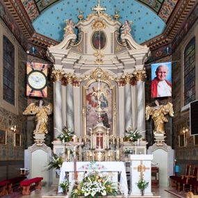 Zdjęcie nr 1: Ołtarz architektoniczny, jednoosiowy z bramkami, jednokondygnacyjny ze zwieńczeniem, na podwójnym cokole. Ołtarz murowany, licowany kamiennymi płytami, prostopadłościenny. Mensa betonowa. Antependium w formie wydłużonego, leżącego prostokąta, ujętego profilowaną ramą. Na srebrzonym polu płaskorzeźbiona, złocona dekoracja; w centrum rocaillowy kartusz ze sceną Zwiastowania Najświętszej Marii Panny, flankowany parą rocaillowych płycin, w których prawa z przedstawieniem mitry książęcej na poduszce ujętej różanymi gałązkami z gwiazdą, lewa z berłem na poduszce ujętym liliami zwieńczonej słońcem. 
Tabernaculum w formie prostopadłościennej szafki o wypukłej ścianie frontowej, z dwuskrzydłowymi drzwiczkami o kształcie zbliżonym do kwadratu, ujęte ramą; na łączeniu drzwiczek krzyż, flankowany przez odlewane kłosy zbóż i winne grono, całość na fakturowanym tle. Tabernaculum w drewnianej obudowie stanowiącej podstawę dla tronu wystawienia; cokół wyłamany, dekorowany płycinami z ornamentem roślinnym i campanullami; całość zamknięta gzymsem. Tron wystawienia w formie aediculi z obrotową niszą; ujęte parą półkolumn i parą kolumn o kapitelach kompozytowych i pseudokanelowanych trzonach dźwigających pełne belkowanie, wypukłe i wyłamane na kształt łuku odcinkowego nad niszą, wyłamane na osiach podpór. Nisza ujęta opaską dekorowaną akantem. W partii fryzu rozety i dekoracja roślinna. Całość zwieńczona postumentem  z leżącym na księdze barankiem. Tron flankują dwie figurki, adorujących aniołków, klęczących na cokole.
Nastawa ołtarzowa ujęta trzema parami pilastrów i parą skrajnych filarów o kapitelach kompozytowych i kanelowanych trzonach; oraz stojących przed nimi w dwóch strefach dwiema parami kolumn o kapitelach kompozytowych. Podpory dźwigają pełne belkowanie, wyłamane na ich osi; nad polem środkowym architraw przyjmuje kształt łuku nadwieszonego. Belkowanie oraz cokoły kolumn ustawione delikatnie pod katem względem lica retabulum. Na belkowaniu, na osi skrajnych kolumn przerwany, wolutowy przyczółek z siedzącą parą puttów. W polu środkowym  nisza w formie stojącego prostokąta zamkniętego łukiem nadwieszonym, z wklęsłymi dolnymi narożami i dolnym bokiem; ujęta profilowaną ramą; w polu płaskorzeźbiona scena z Widzeniem św. Franciszka. Zwieńczenie w formie stojącego prostokąta ujętego lizenami oraz spływami wolutowymi; zamknięte gzymsem przechodzącym w dwie zwrócone antytetycznie woluty. W polu obraz w formie stojącego owalu w profilowanej ramie z przedstawieniem św. Michała Archanioła. Retabulum ujęte bramkami z przejściami w formie stojącego prostokąta zamkniętego łukiem nadwieszonym z uskokiem, z drzwiczkami; zwieńczone podtrzymywanym przez konsolę cokołem dla figur aniołów, flankowanym spływami wolutowymi.
Cokoły dla kolumn dekorowane z trzech stron płycinami. Rama obrazu pola środkowego zdobiona na bokach rocaille z kwiatami i palmami; łuk zwieńczony rocaillowym kartuszem, flankowanym przez dwie palmy. Na gzymsie nad polem środkowym muszla. Lizeny i woluty zwieńczenia dekorowane campanullami; obraz u spodu i u góry ujęty rocaille. Na gzymsie wieńczącym dwa kwiatowe festony; na jego skraju para wazonów, całość zwieńczona stylizowanym rokokowym krzyżem.
Struktura polichromowana w kolorze kremowym, z detalami w kolorach szarym i brudnym różem; trzony kolumn marmoryzowane; ornamentyka i profile złocone.