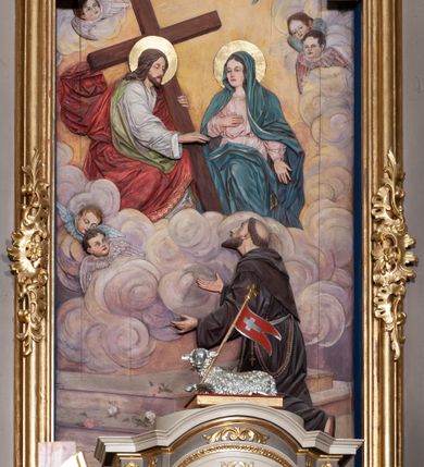 Zdjęcie nr 5: Ołtarz architektoniczny, jednoosiowy z bramkami, jednokondygnacyjny ze zwieńczeniem, na podwójnym cokole. Ołtarz murowany, licowany kamiennymi płytami, prostopadłościenny. Mensa betonowa. Antependium w formie wydłużonego, leżącego prostokąta, ujętego profilowaną ramą. Na srebrzonym polu płaskorzeźbiona, złocona dekoracja; w centrum rocaillowy kartusz ze sceną Zwiastowania Najświętszej Marii Panny, flankowany parą rocaillowych płycin, w których prawa z przedstawieniem mitry książęcej na poduszce ujętej różanymi gałązkami z gwiazdą, lewa z berłem na poduszce ujętym liliami zwieńczonej słońcem. 
Tabernaculum w formie prostopadłościennej szafki o wypukłej ścianie frontowej, z dwuskrzydłowymi drzwiczkami o kształcie zbliżonym do kwadratu, ujęte ramą; na łączeniu drzwiczek krzyż, flankowany przez odlewane kłosy zbóż i winne grono, całość na fakturowanym tle. Tabernaculum w drewnianej obudowie stanowiącej podstawę dla tronu wystawienia; cokół wyłamany, dekorowany płycinami z ornamentem roślinnym i campanullami; całość zamknięta gzymsem. Tron wystawienia w formie aediculi z obrotową niszą; ujęte parą półkolumn i parą kolumn o kapitelach kompozytowych i pseudokanelowanych trzonach dźwigających pełne belkowanie, wypukłe i wyłamane na kształt łuku odcinkowego nad niszą, wyłamane na osiach podpór. Nisza ujęta opaską dekorowaną akantem. W partii fryzu rozety i dekoracja roślinna. Całość zwieńczona postumentem  z leżącym na księdze barankiem. Tron flankują dwie figurki, adorujących aniołków, klęczących na cokole.
Nastawa ołtarzowa ujęta trzema parami pilastrów i parą skrajnych filarów o kapitelach kompozytowych i kanelowanych trzonach; oraz stojących przed nimi w dwóch strefach dwiema parami kolumn o kapitelach kompozytowych. Podpory dźwigają pełne belkowanie, wyłamane na ich osi; nad polem środkowym architraw przyjmuje kształt łuku nadwieszonego. Belkowanie oraz cokoły kolumn ustawione delikatnie pod katem względem lica retabulum. Na belkowaniu, na osi skrajnych kolumn przerwany, wolutowy przyczółek z siedzącą parą puttów. W polu środkowym  nisza w formie stojącego prostokąta zamkniętego łukiem nadwieszonym, z wklęsłymi dolnymi narożami i dolnym bokiem; ujęta profilowaną ramą; w polu płaskorzeźbiona scena z Widzeniem św. Franciszka. Zwieńczenie w formie stojącego prostokąta ujętego lizenami oraz spływami wolutowymi; zamknięte gzymsem przechodzącym w dwie zwrócone antytetycznie woluty. W polu obraz w formie stojącego owalu w profilowanej ramie z przedstawieniem św. Michała Archanioła. Retabulum ujęte bramkami z przejściami w formie stojącego prostokąta zamkniętego łukiem nadwieszonym z uskokiem, z drzwiczkami; zwieńczone podtrzymywanym przez konsolę cokołem dla figur aniołów, flankowanym spływami wolutowymi.
Cokoły dla kolumn dekorowane z trzech stron płycinami. Rama obrazu pola środkowego zdobiona na bokach rocaille z kwiatami i palmami; łuk zwieńczony rocaillowym kartuszem, flankowanym przez dwie palmy. Na gzymsie nad polem środkowym muszla. Lizeny i woluty zwieńczenia dekorowane campanullami; obraz u spodu i u góry ujęty rocaille. Na gzymsie wieńczącym dwa kwiatowe festony; na jego skraju para wazonów, całość zwieńczona stylizowanym rokokowym krzyżem.
Struktura polichromowana w kolorze kremowym, z detalami w kolorach szarym i brudnym różem; trzony kolumn marmoryzowane; ornamentyka i profile złocone.