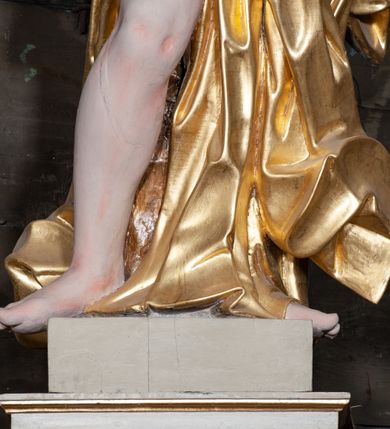 Zdjęcie nr 12: Ołtarz architektoniczny, jednoosiowy z bramkami, jednokondygnacyjny ze zwieńczeniem, na podwójnym cokole. Ołtarz murowany, licowany kamiennymi płytami, prostopadłościenny. Mensa betonowa. Antependium w formie wydłużonego, leżącego prostokąta, ujętego profilowaną ramą. Na srebrzonym polu płaskorzeźbiona, złocona dekoracja; w centrum rocaillowy kartusz ze sceną Zwiastowania Najświętszej Marii Panny, flankowany parą rocaillowych płycin, w których prawa z przedstawieniem mitry książęcej na poduszce ujętej różanymi gałązkami z gwiazdą, lewa z berłem na poduszce ujętym liliami zwieńczonej słońcem. 
Tabernaculum w formie prostopadłościennej szafki o wypukłej ścianie frontowej, z dwuskrzydłowymi drzwiczkami o kształcie zbliżonym do kwadratu, ujęte ramą; na łączeniu drzwiczek krzyż, flankowany przez odlewane kłosy zbóż i winne grono, całość na fakturowanym tle. Tabernaculum w drewnianej obudowie stanowiącej podstawę dla tronu wystawienia; cokół wyłamany, dekorowany płycinami z ornamentem roślinnym i campanullami; całość zamknięta gzymsem. Tron wystawienia w formie aediculi z obrotową niszą; ujęte parą półkolumn i parą kolumn o kapitelach kompozytowych i pseudokanelowanych trzonach dźwigających pełne belkowanie, wypukłe i wyłamane na kształt łuku odcinkowego nad niszą, wyłamane na osiach podpór. Nisza ujęta opaską dekorowaną akantem. W partii fryzu rozety i dekoracja roślinna. Całość zwieńczona postumentem  z leżącym na księdze barankiem. Tron flankują dwie figurki, adorujących aniołków, klęczących na cokole.
Nastawa ołtarzowa ujęta trzema parami pilastrów i parą skrajnych filarów o kapitelach kompozytowych i kanelowanych trzonach; oraz stojących przed nimi w dwóch strefach dwiema parami kolumn o kapitelach kompozytowych. Podpory dźwigają pełne belkowanie, wyłamane na ich osi; nad polem środkowym architraw przyjmuje kształt łuku nadwieszonego. Belkowanie oraz cokoły kolumn ustawione delikatnie pod katem względem lica retabulum. Na belkowaniu, na osi skrajnych kolumn przerwany, wolutowy przyczółek z siedzącą parą puttów. W polu środkowym  nisza w formie stojącego prostokąta zamkniętego łukiem nadwieszonym, z wklęsłymi dolnymi narożami i dolnym bokiem; ujęta profilowaną ramą; w polu płaskorzeźbiona scena z Widzeniem św. Franciszka. Zwieńczenie w formie stojącego prostokąta ujętego lizenami oraz spływami wolutowymi; zamknięte gzymsem przechodzącym w dwie zwrócone antytetycznie woluty. W polu obraz w formie stojącego owalu w profilowanej ramie z przedstawieniem św. Michała Archanioła. Retabulum ujęte bramkami z przejściami w formie stojącego prostokąta zamkniętego łukiem nadwieszonym z uskokiem, z drzwiczkami; zwieńczone podtrzymywanym przez konsolę cokołem dla figur aniołów, flankowanym spływami wolutowymi.
Cokoły dla kolumn dekorowane z trzech stron płycinami. Rama obrazu pola środkowego zdobiona na bokach rocaille z kwiatami i palmami; łuk zwieńczony rocaillowym kartuszem, flankowanym przez dwie palmy. Na gzymsie nad polem środkowym muszla. Lizeny i woluty zwieńczenia dekorowane campanullami; obraz u spodu i u góry ujęty rocaille. Na gzymsie wieńczącym dwa kwiatowe festony; na jego skraju para wazonów, całość zwieńczona stylizowanym rokokowym krzyżem.
Struktura polichromowana w kolorze kremowym, z detalami w kolorach szarym i brudnym różem; trzony kolumn marmoryzowane; ornamentyka i profile złocone.